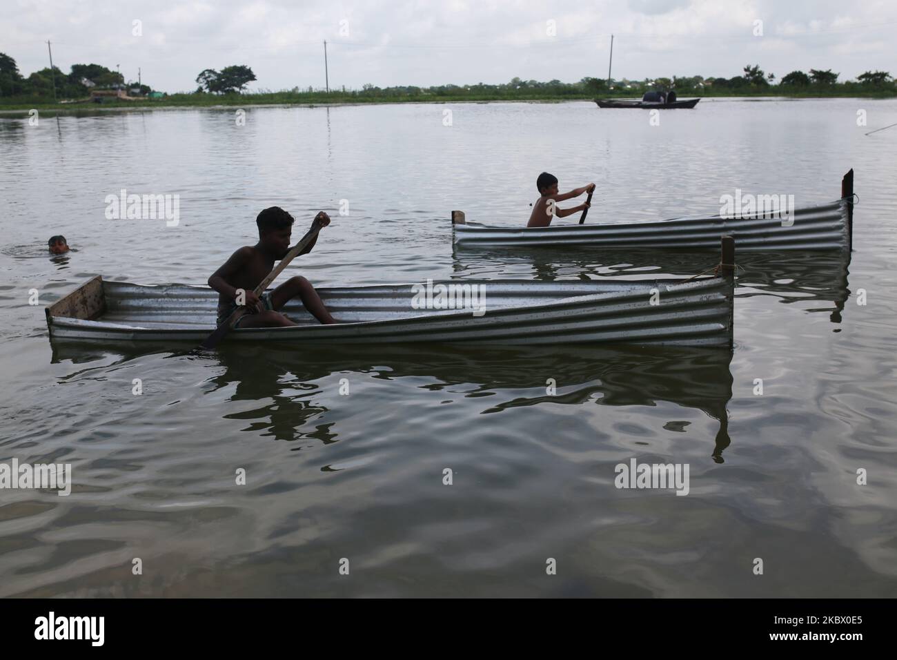 Kinder spielen am 10. August 2020 auf dem Flutwasser in Narayanganj, in der Nähe von Dhaka, Bangladesch, mit winzigen Booten. (Foto von Rehman Asad/NurPhoto) Stockfoto