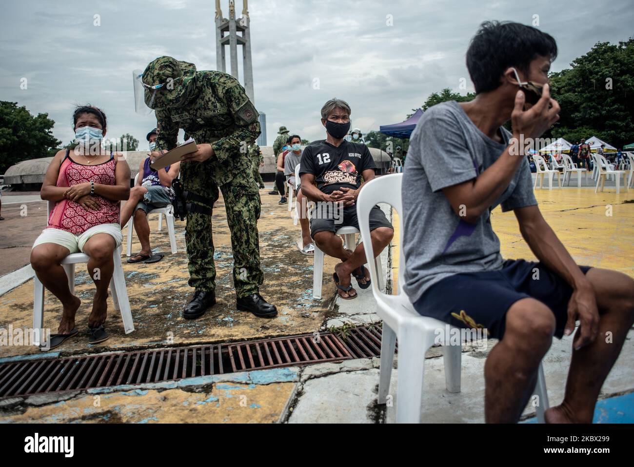 Ein Quarantäneverletzer unterzieht sich einem Buchungsprozess, bevor er am 12. August 2020 an einem Vortrag über COVID-19-Prävention im Quezon Memorial Circle in Quezon City, Philippinen, teilnimmt. Seit der Sperrung im März wurden auf den Philippinen mehr als 300.000 Quarantäneverletzer festgenommen. Zu den Verstößen gehören das Tragen einer Gesichtsmaske, die Teilnahme an einer Massenversammlung und das Trinken während eines Alkoholverbots. (Foto: Lisa Marie David/NurPhoto) Stockfoto