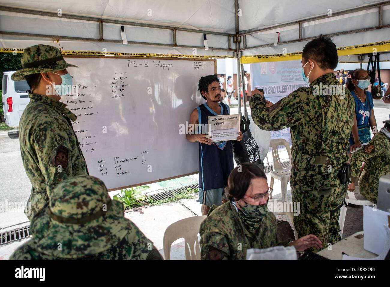 Ein Quarantäneverletzer unterzieht sich einem Buchungsprozess, bevor er am 12. August 2020 an einem Vortrag über COVID-19-Prävention im Quezon Memorial Circle in Quezon City, Philippinen, teilnimmt. Seit der Sperrung im März wurden auf den Philippinen mehr als 300.000 Quarantäneverletzer festgenommen. Zu den Verstößen gehören das Tragen einer Gesichtsmaske, die Teilnahme an einer Massenversammlung und das Trinken während eines Alkoholverbots. (Foto: Lisa Marie David/NurPhoto) Stockfoto