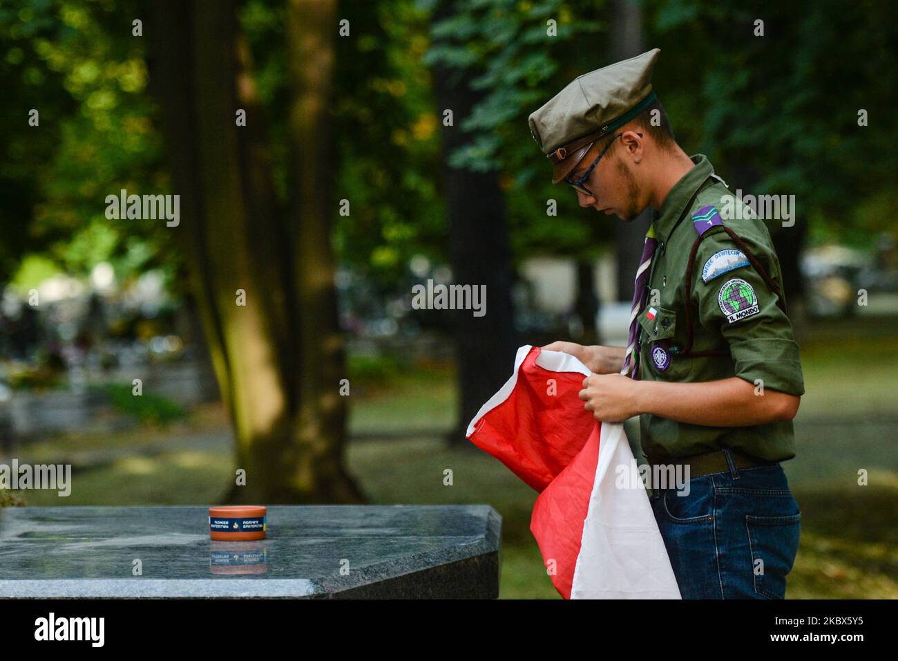 Ein lokaler Pfadfinder hält die polnische Nationalflagge als Vorbereitung vor der Zeremonie. Hunderte von Pfadfindern nahmen an der Kampagne „Flamme der Bruderschaft“ Teil, einer gemeinsamen Initiative polnischer und ukrainischer Pfadfinder. Die Teilnehmer trafen sich auf Dutzenden von Friedhofs in Polen, um die Erinnerung an ukrainische Soldaten zu ehren - Helden Polens im Freiheitskampf während des polnisch-sowjetischen Krieges 1919-1921. Die Flamme der Bruderschaft wurde angezündet. Am Freitag, den 14. August 2020, in Krakau, Polen. (Foto von Artur Widak/NurPhoto) Stockfoto