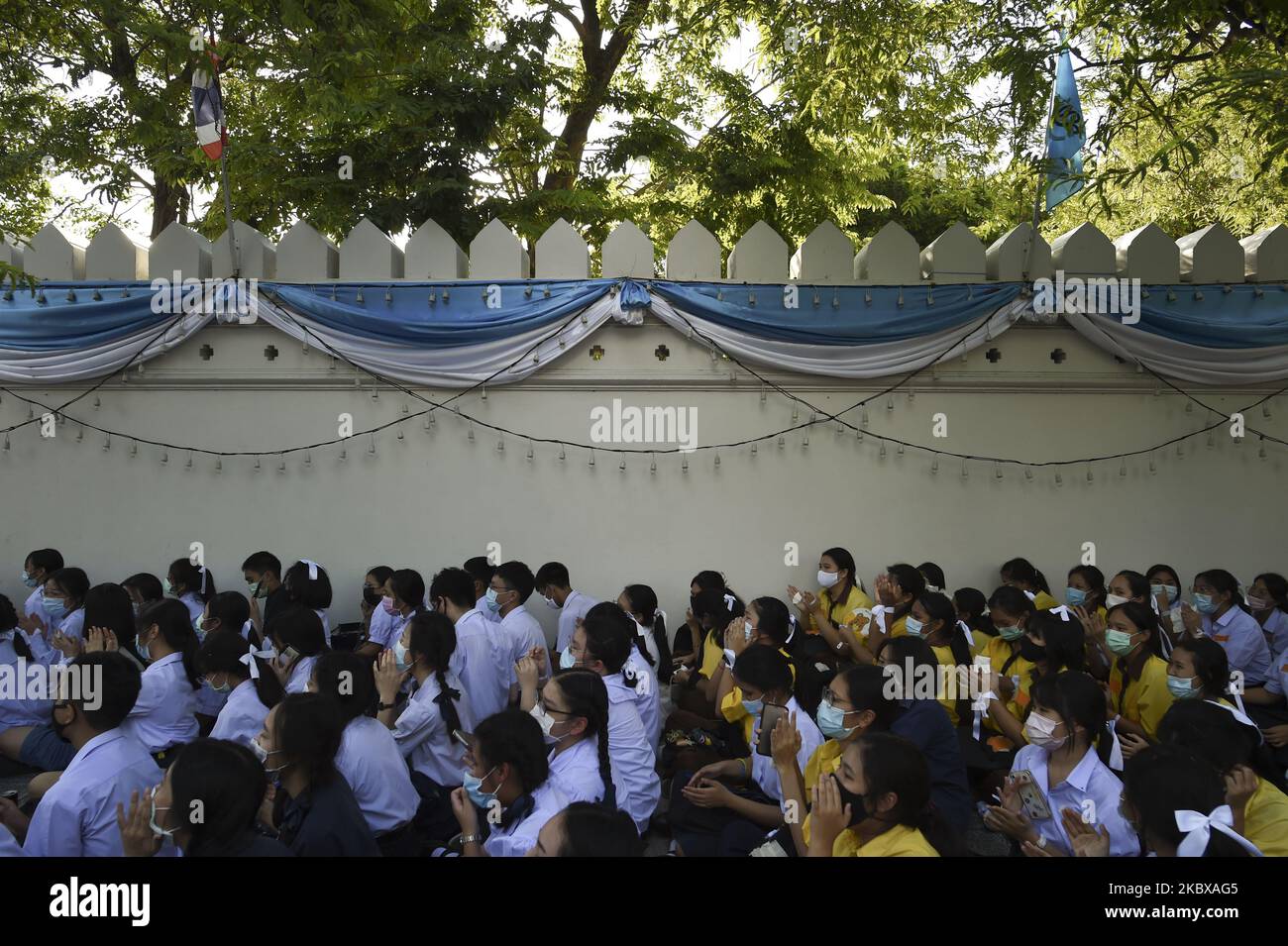 Ein Student, der Schutzmasken trägt, bindet ein weißes Band an die Haare, um Unterstützung für die studentisch geführte Demokratiebewegung außerhalb des Bildungsministeriums in Bangkok, Thailand, zu zeigen. 19. August 2020. (Foto von Anusak Laowias/NurPhoto) Stockfoto