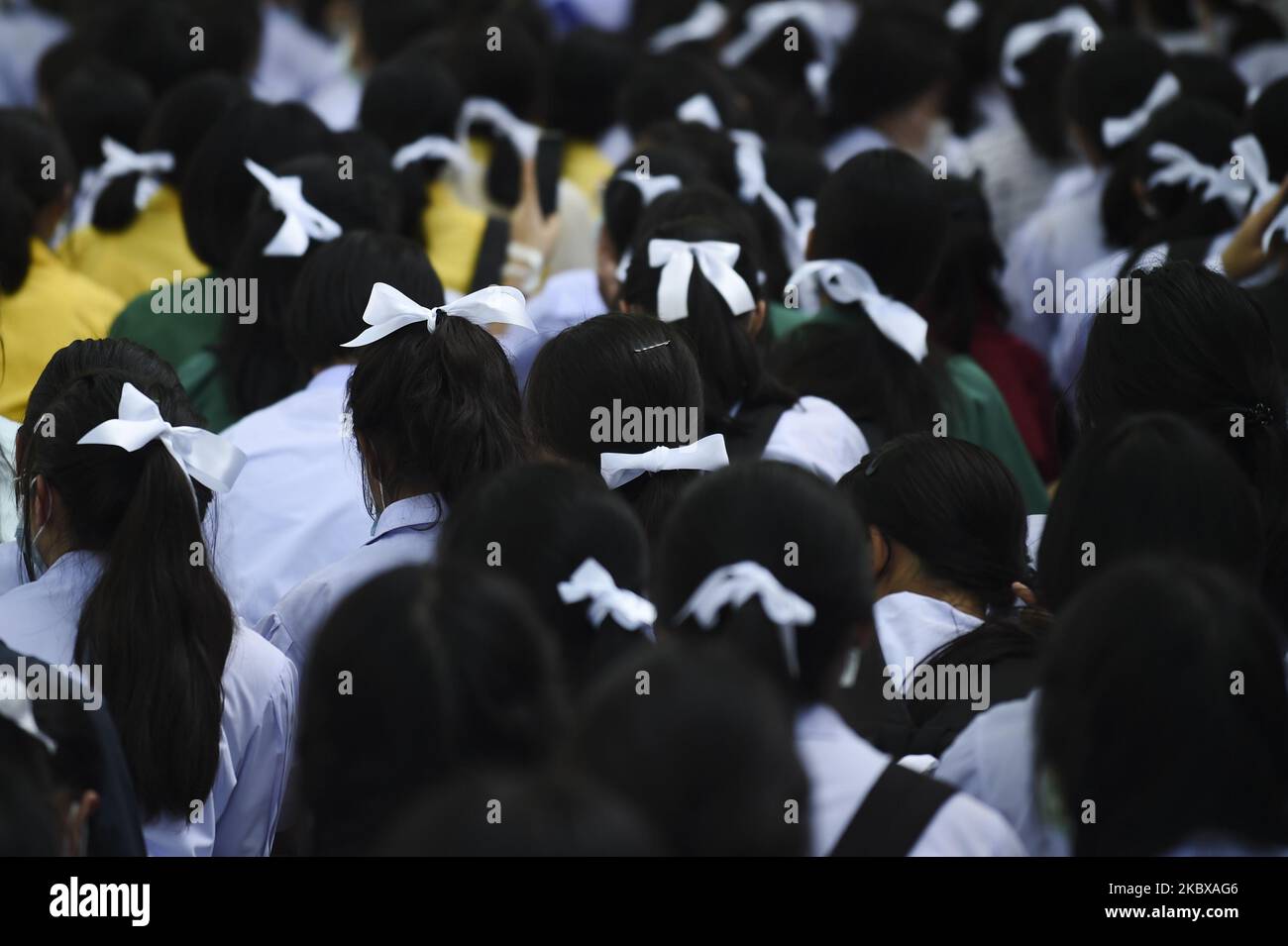 Ein Student bindet ein weißes Band an die Haare, um die Unterstützung für die von Studenten geführte Demokratiebewegung außerhalb des Bildungsministeriums in Bangkok, Thailand, zu zeigen. 19. August 2020. (Foto von Anusak Laowias/NurPhoto) Stockfoto