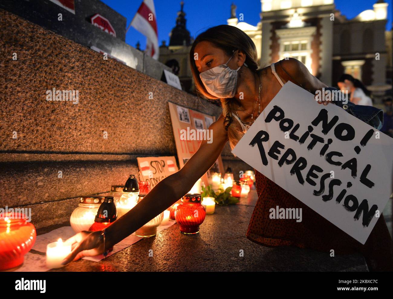 Ein Protestler legt neben dem Adam-Mickiewicz-Denkmal eine Kerze. Seit den umstrittenen Wahlen in Belarus protestieren Mitglieder der belarussischen Diaspora in vielen Städten in ganz Europa, einschließlich Krakau. Gestern Abend fand auf dem Marktplatz in Krakau ein weiterer Protest gegen Alexander Lukaschenko statt. Am 20. August 2020 in Krakau, Polen. (Foto von Artur Widak/NurPhoto) Stockfoto