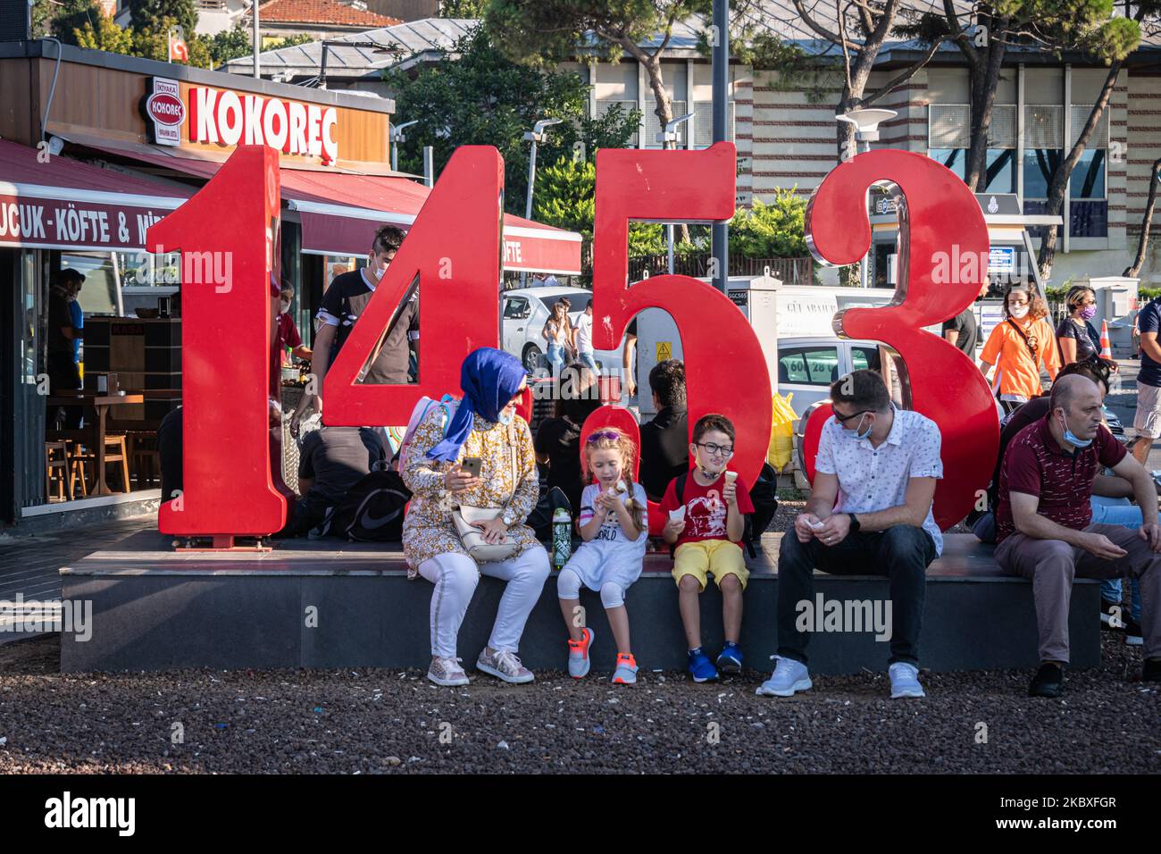 Am 23. August 2020 gingen Bürger der größten Stadt der Türkei, Istanbul, am 24. August 2020, an einem Sonntagnachmittag zu Freizeitaktivitäten und verfolgten tägliche Routinen, während sie Gesichtsmasken trugen, wie von der türkischen Regierung gefordert, um die Ausbreitung von Covid-19 zu reduzieren. Auf dem Bild oben isst eine Familie Eis auf einer Skulptur, die das Datum der türkischen Eroberung Konstantinopels in Uskudar, Istanbul, ehrt. (Foto von Diego Cupolo/NurPhoto) Stockfoto