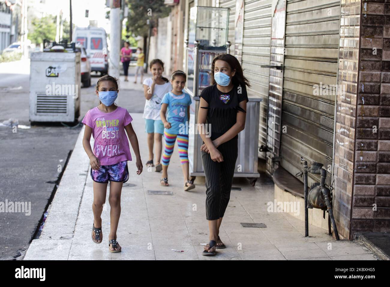 Palästinensische Mädchen, die am 25. August 2020 während eines Spaziergangs auf der Straße in Gaza-Stadt eine Gesichtsmaske trugen. Der belagerte Gazastreifen wurde vollständig gesperrt, nachdem die Behörden bestätigt hatten, dass sich die ersten Coronavirus-Fälle über die Gemeinschaft ausbreiteten, was die Befürchtungen vor einem potenziell verheerenden Ausbruch in dem verarmten palästinensischen Gebiet ausschürte. Das Gesundheitsministerium sagte, dass vier Personen derselben Familie im zentralen Gaza-Streifen positiv getestet wurden und am Montagabend eine 48-stündige Sperre im gesamten Gebiet in Kraft trat, einschließlich des Flüchtlingslagers al-Maghazi, in dem die Familie lebt. Schoo Stockfoto