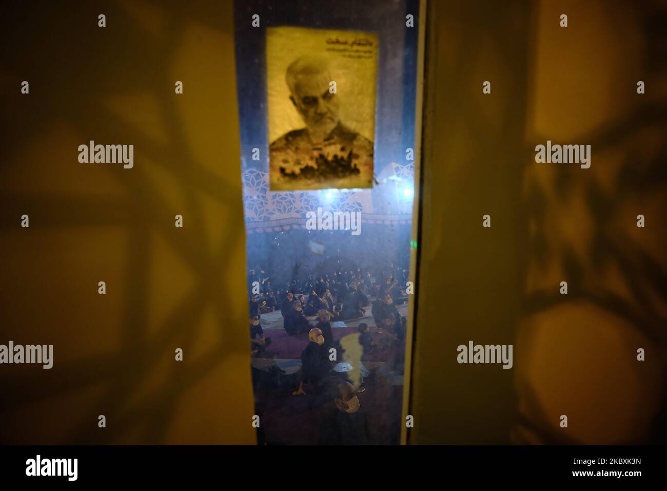 Iranische schiitische Trauernde nehmen an einer religiösen Zeremonie in Moharram Teil, während am 25. August 2020 auf dem Imam-Hussein-Platz im Süden Teherans ein Porträt der ehemaligen Qasem Soleimani (Qasem Soleimani), eines ehemaligen Qods Force der Islamischen Revolutionsgarde (IRGC), auf einem Grabfenster von Märtyrern des Iran-Irak-Krieges (1980-88) zu sehen ist. Schiitische Trauernde haben an einer religiösen Zeremonie anlässlich des heiligen Monats Moharram teilgenommen, während Gesundheitsbeamte religiöse Führer aufforderten, die Gesundheitsprotokolle zu befolgen, um weitere Ausbrüche der neuen Coronavirus-Krankheit zu verhindern. (Foto von Morteza Nikoubazl/NurPhoto) Stockfoto
