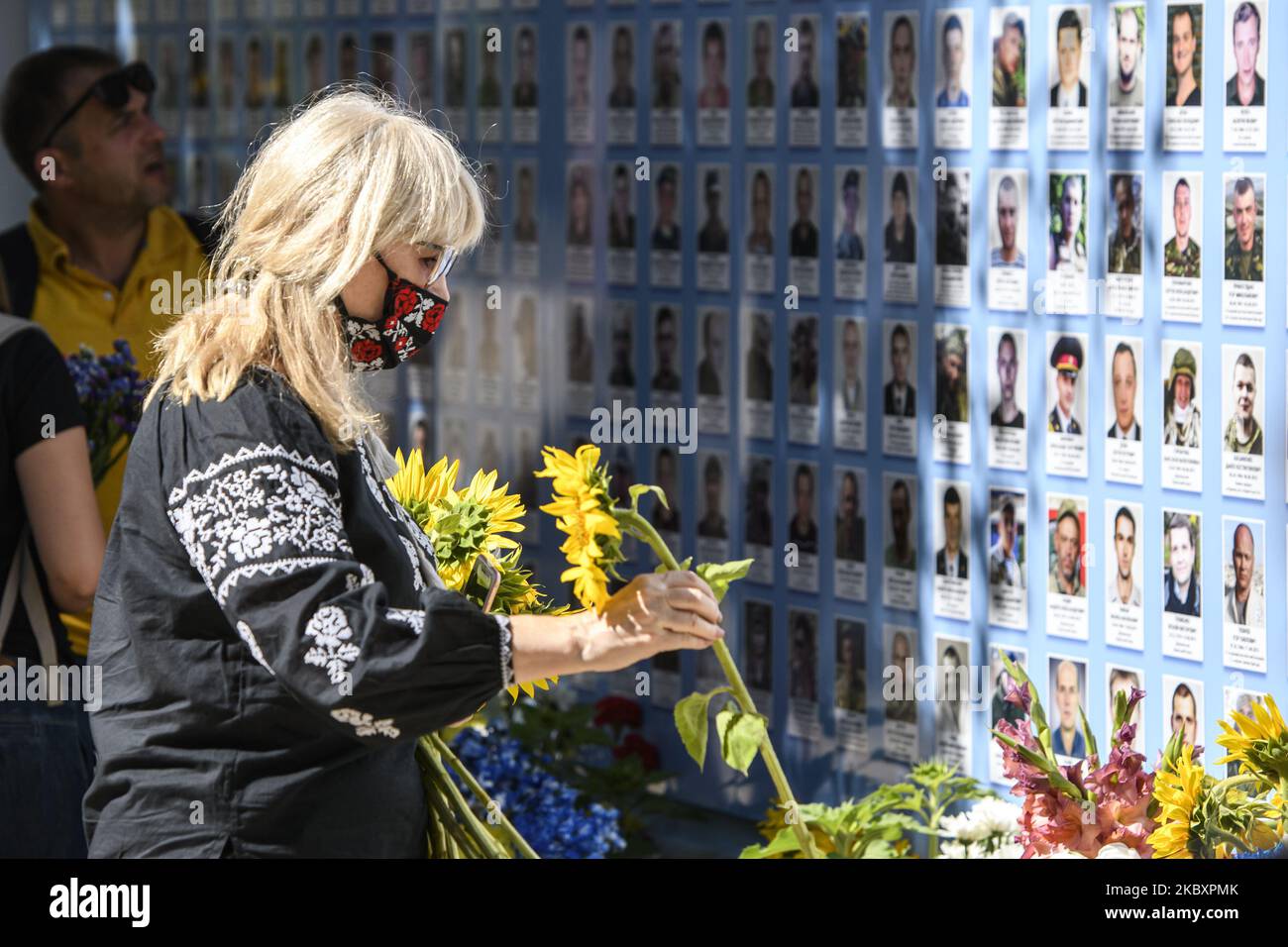 Ukrainer legen Blumen an die Gedenkmauer der gefallenen Verteidiger der Ukraine im Krieg in der Ostukraine 2014-2020 während einer Gedenkfeier zum Gedenktag der gefallenen Verteidiger der Ukraine in Kiew, Ukraine, 29. August 2020. (Foto von Maxym Marusenko/NurPhoto) Stockfoto