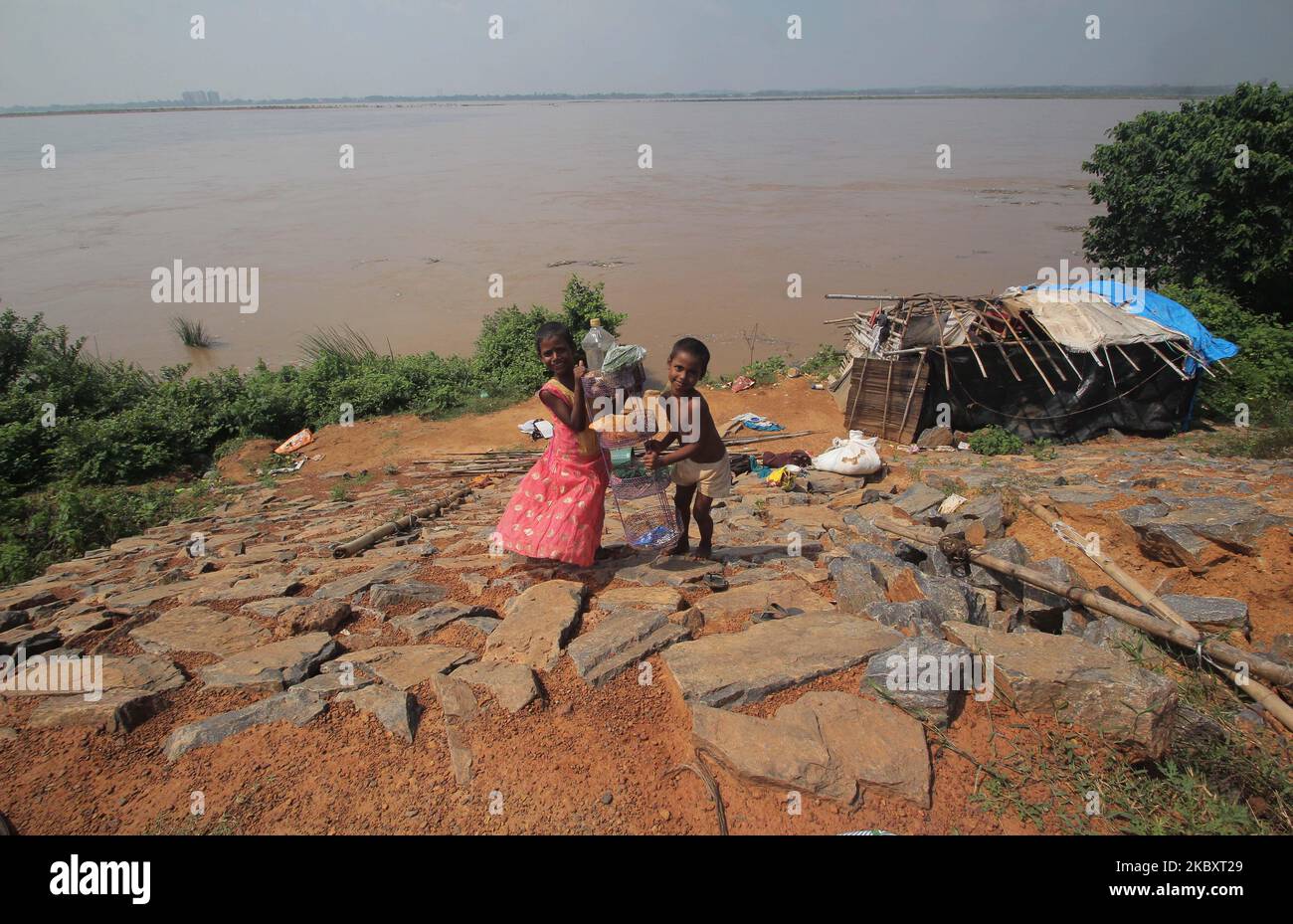 Die Dorfbewohner in tiefer gelegenen Gebieten werden als ihre Häuser in den Hirakud-Staudamm des Mahanadi-Flusses eingetaucht, der nur am Rande von Bhubaneswar liegt und in seinen Nebenflüssen in abwärts fließende Flüsse kreuzt, nachdem das Hochwasser des Damms aufgrund des starken Regenfalls im oberen Einzugsgebiet freigesetzt wurde und es zu einer Überschwemmungssituation und führt Niedrig liegende lebende Völker kommen zu den Flussdämmen, um Schutz zu erhalten, da über Hunderten von Dörfern in 10 Distrikten am 30,2020. August in den Küstengebieten des ostindischen Staates Odisha, Bhubaneswar, Indien, von dem Hochwasser betroffen war. (Foto von STR/NurPhoto) Stockfoto