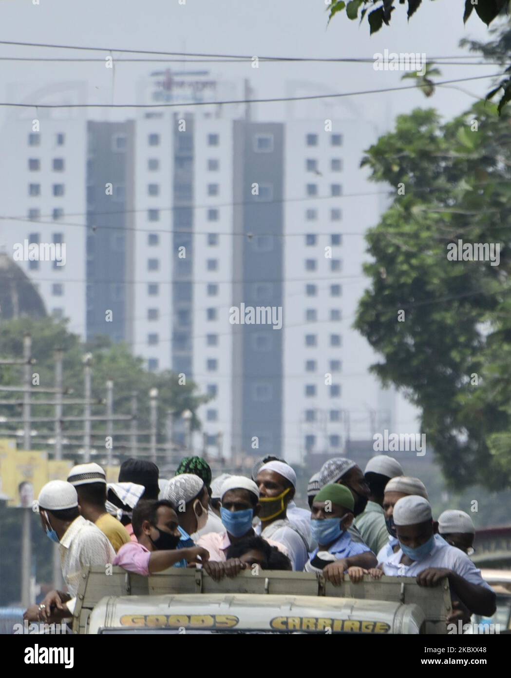 Menschen stehen auf einem Mini-Truck, ohne die soziale Distanzierung aufrecht zu erhalten, während eine Regierung des Bundesstaates, die während eines Coronavirus-Notfalls in Kalkutta, Indien, am 31. August 2020, eine Sperre verhängte. (Foto von Indranil Aditya/NurPhoto) Stockfoto