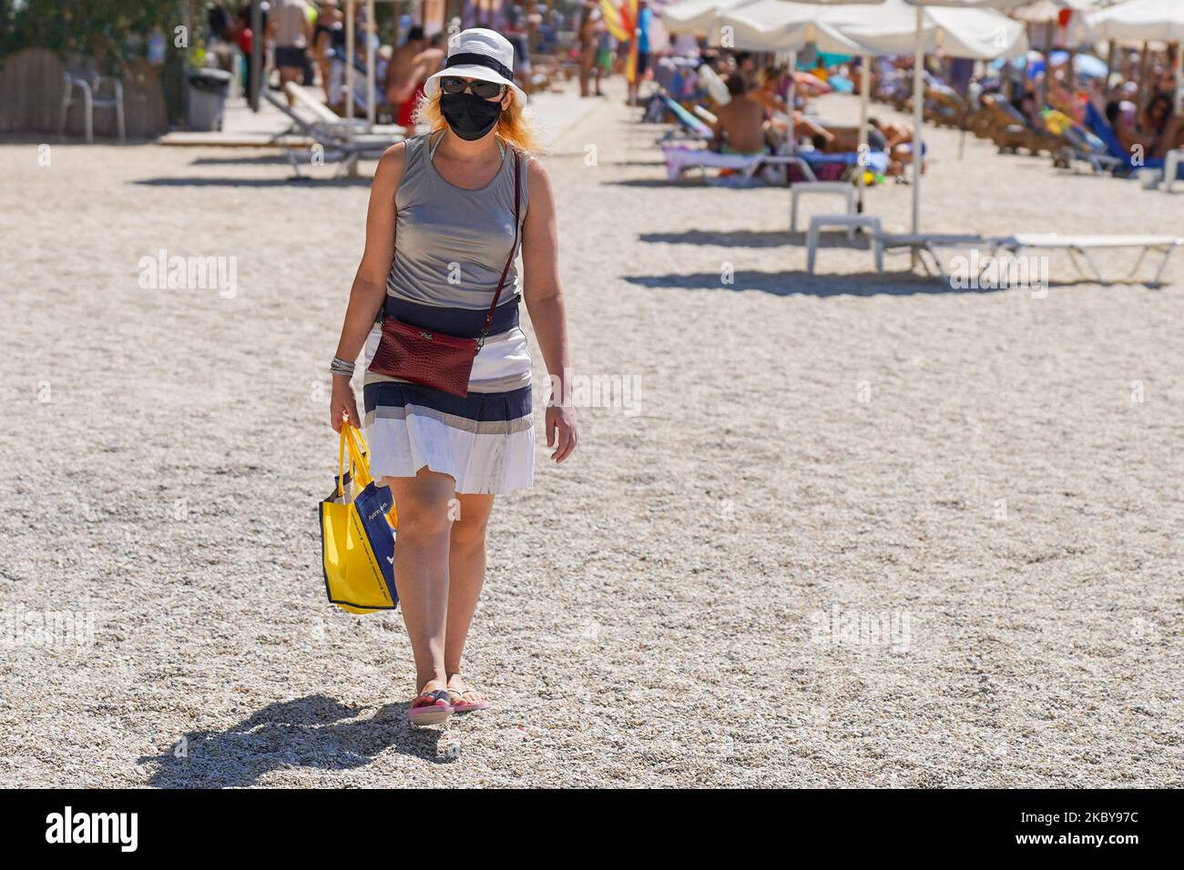 Eine Frau trägt eine Gesichtsmaske, während sie am 6. September 2020 am Strand von Palaio Faliro in Athen, Griechenland, spazieren geht. (Foto von Giannis Alexopoulos/NurPhoto) Stockfoto