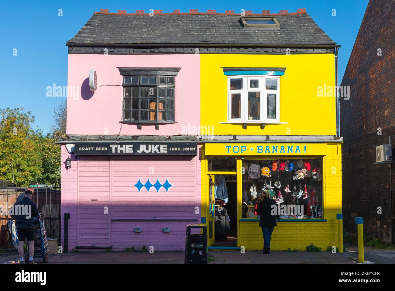 Farbenfrohe rosa und gelbe Geschäfte nebeneinander in York Road, Kings Heath, Birmingham Stockfoto