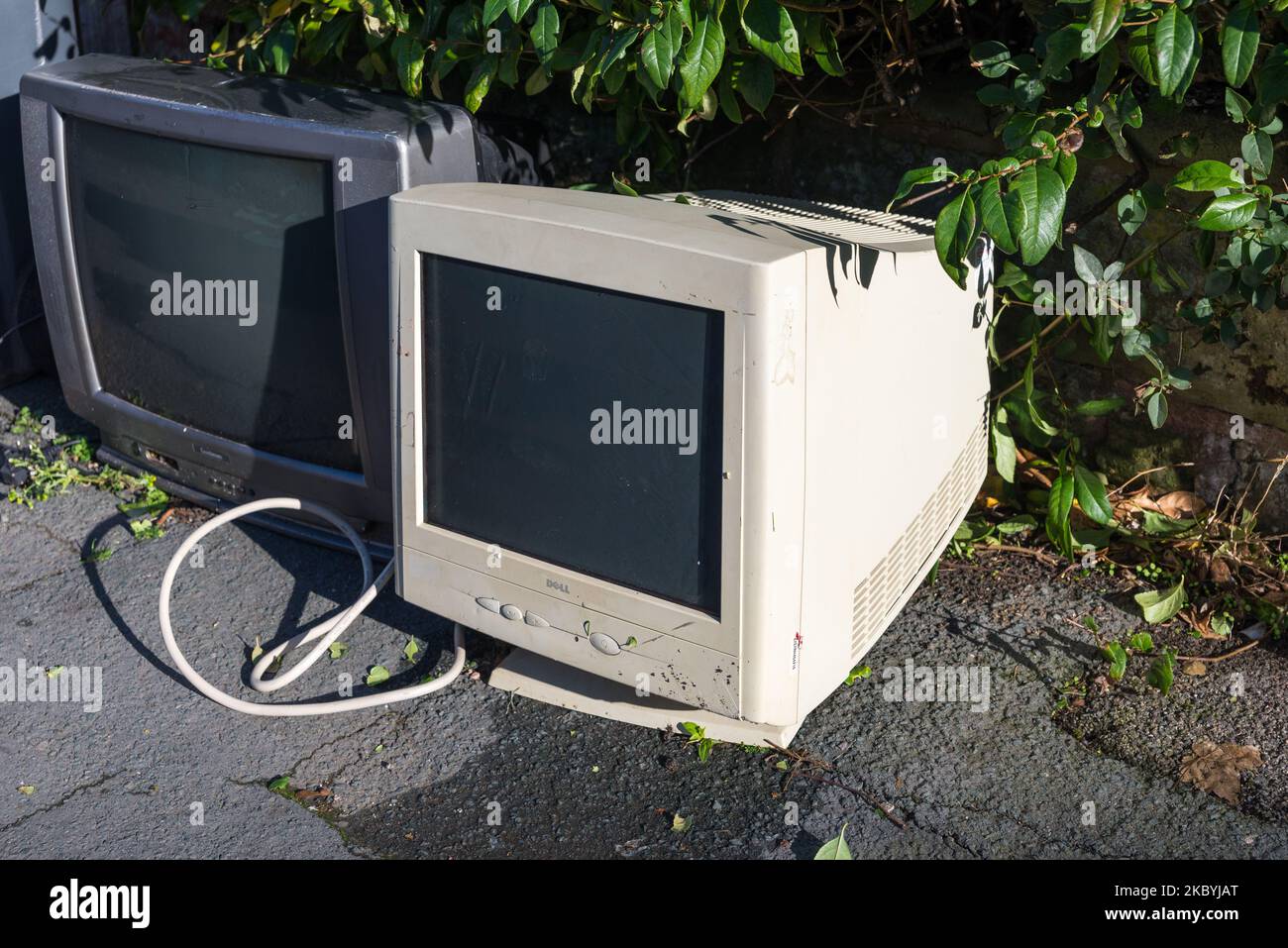 Alte röhrenfernseher und Computermonitor wurden zur Abholung oder Entsorgung auf dem Bürgersteig gelassen Stockfoto