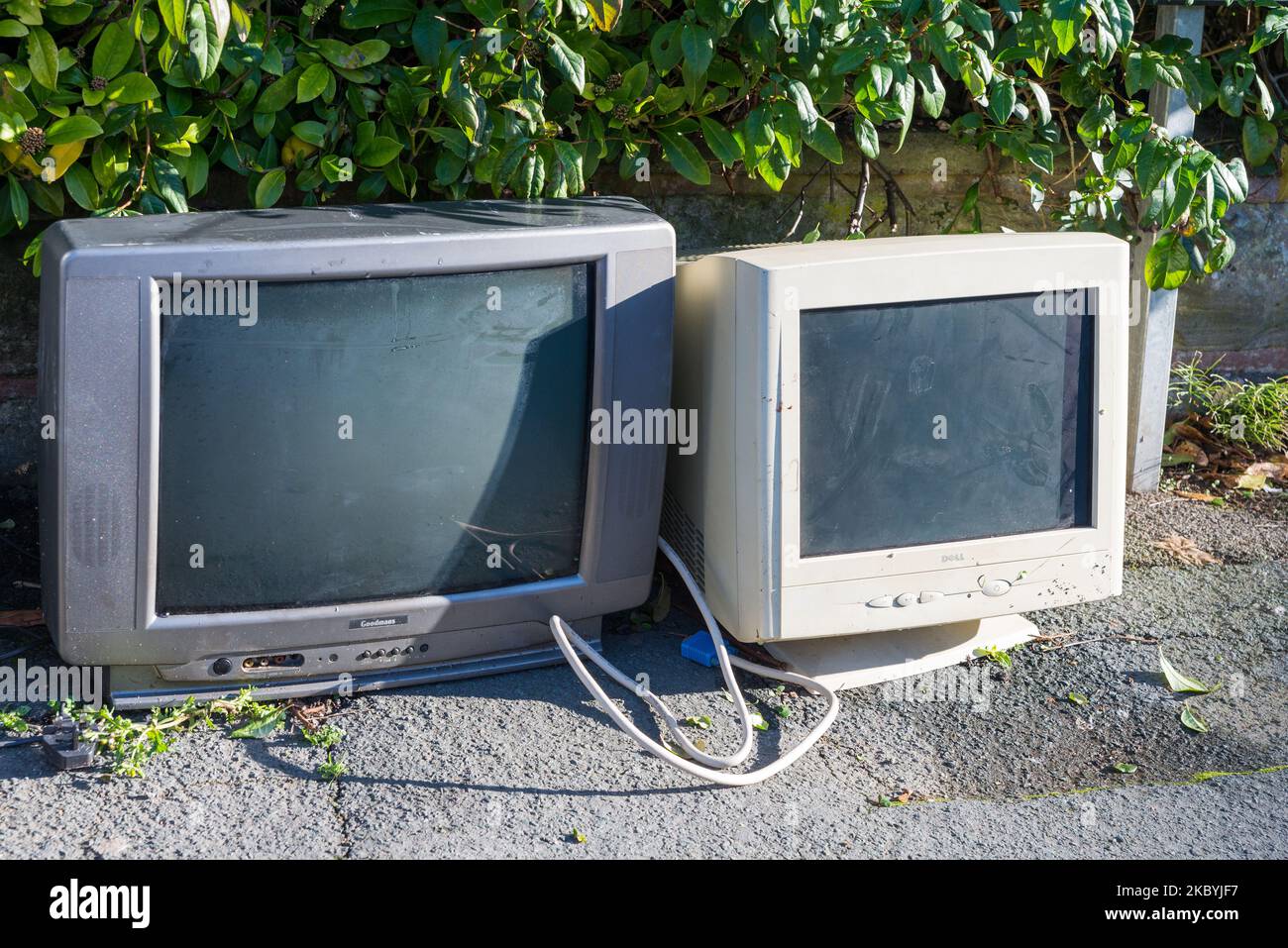 Alte röhrenfernseher und Computermonitor wurden zur Abholung oder Entsorgung auf dem Bürgersteig gelassen Stockfoto