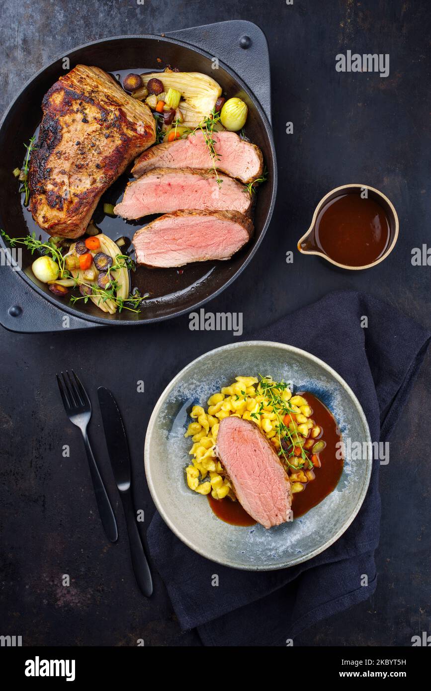 Tafelspitz Kalbsbraten mit schwäbischem Spätzle serviert mit dunkler Biersauce als Draufsicht in einer Design-Schüssel und einem Topf Stockfoto