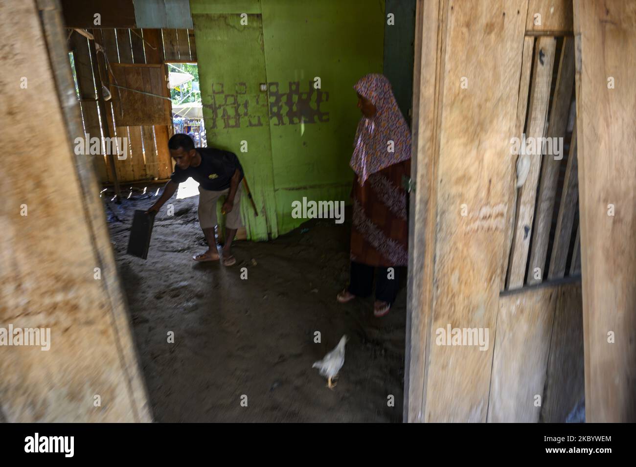 Am 14. September 2020 reinigen die Bewohner die Schlammpfütze in ihrem Haus im Dorf Pandere, Bezirk Gumbasa, Sigi Regency, Provinz Zentral-Sulawesi, Indonesien. Vier Häuser im Dorf wurden beschädigt und eine Reihe anderer Häuser wurden mit Schlamm überflutet, nachdem heftige Regenfälle den Fluss mit Schlamm überschwemmt hatten. Und überflutete die Häuser der Bewohner am Sonntagabend (13/9/2020). Sigi Regency ist ein Gebiet, das sehr anfällig für hydrometeorologische Katastrophen ist, weil es aus vielen Flüssen und Berghängen sowie hohen Niederschlägen jedes Jahr besteht. (Foto von Basri Marzuki/NurPhoto) Stockfoto