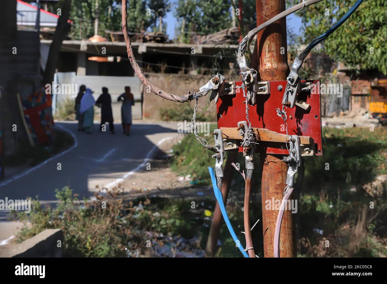 Kashmirische Frauen werden am 19. September 2020 in der Nähe der Stromleitungen gesehen, die an einen Stromtransformator in der Nähe eines Wohngebiets in Baramulla, Jammu und Kashmir, Indien, angeschlossen sind. (Foto von Nasir Kachroo/NurPhoto) Stockfoto