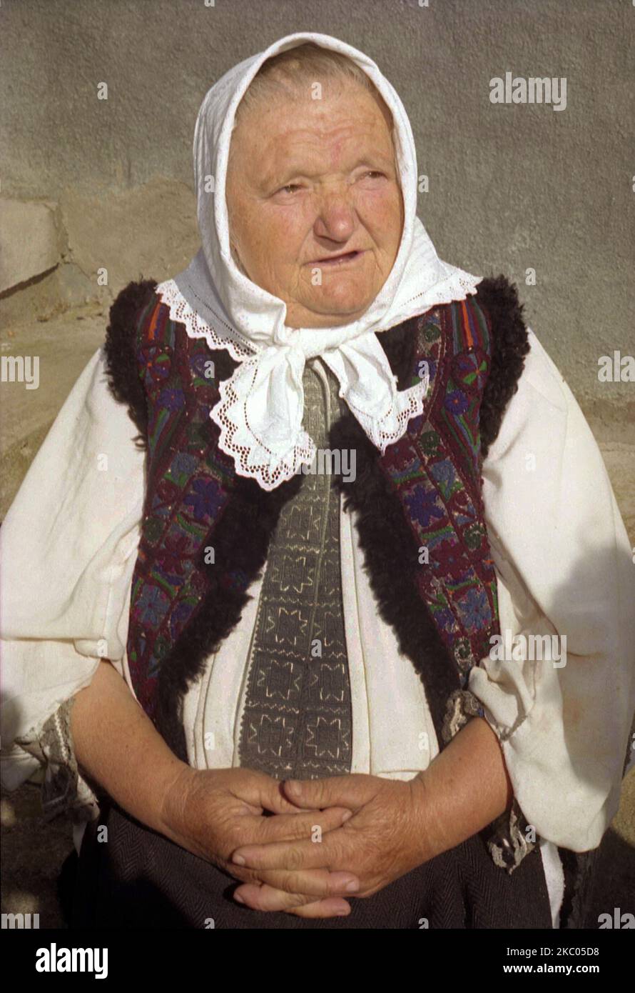 Ältere Frau in traditioneller Tracht in Hunedoara County, Rumänien, ca. 2001. Das weiße Kopftuch wird vor Ort von verheirateten Frauen getragen, während die weiße und graue Kleidung speziell für ältere Frauen geeignet ist. Stockfoto