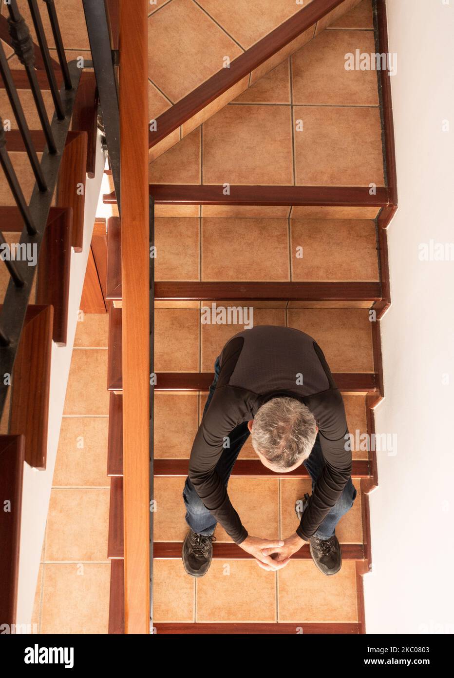 Reifer Mann sitzt auf der Treppe Stockfoto