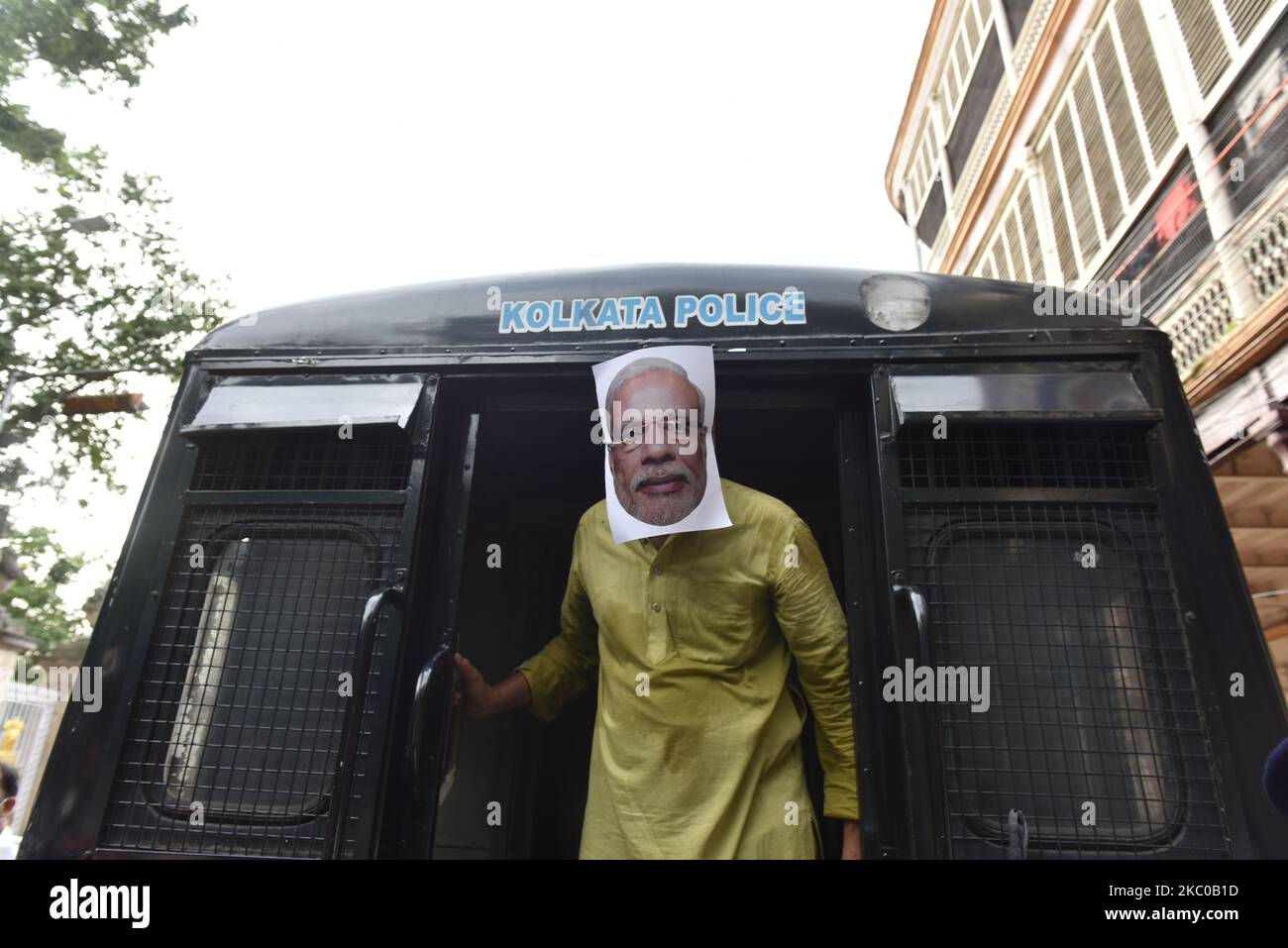 Ein Protestler steht in einem Polizeiwagen mit Modi-Maske, der von der Polizei während einer Agitation des Jugendkongresses vor Raj Bhavan am 21. September 2020 in Kalkutta, Indien, festgenommen wurde. (Foto von Sukhomoy Sen/NurPhoto) Stockfoto