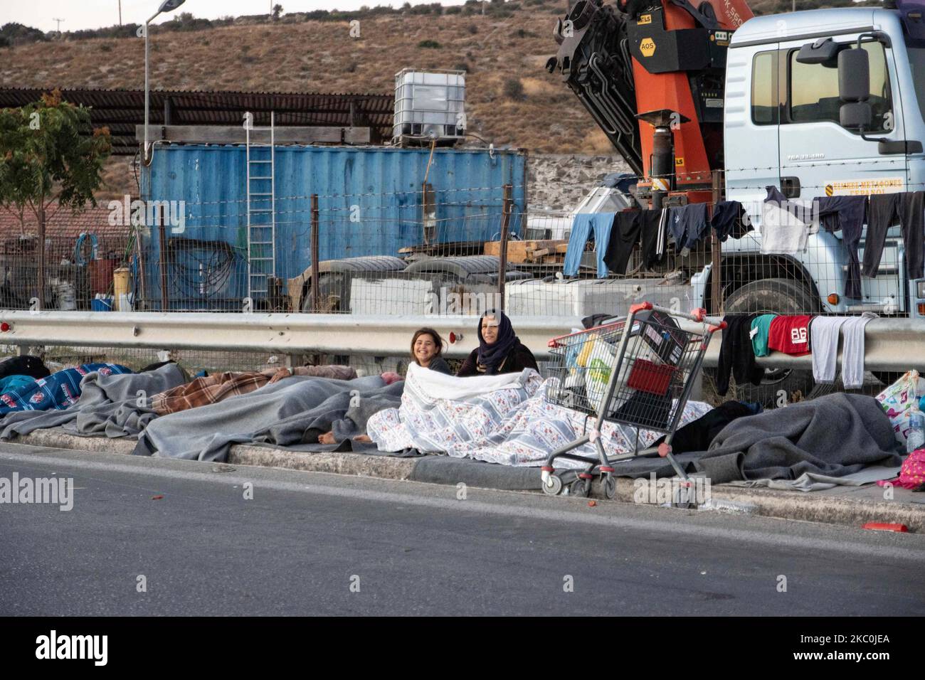 Flüchtlinge und Migranten schlafen auf der Straße. Am frühen Morgen schlafen mehr als 10,000 Asylsuchende nach dem Brand im Moria-Flüchtlingslager, dem Hotspot-Zentrum für Identifikation und Registrierung, am Straßenrand. Obdachlose Flüchtlinge und Migranten ohne Unterkünfte oder Einrichtungen wie Toiletten oder fließendes Wasser leben auf der Straße zwischen Mytilene oder Mitlini Stadt, der Hauptstadt der Insel und Moria, in der Nähe von Caratepe, was die Hauptstraße der Insel zu schließen, In provisorischen Zelten, da es zu dieser Zeit keinen Platz für sie gab, wurde später das neue provisorische Kara Tepe- oder Mavrovouni-Flüchtlingslager errichtet. Stockfoto