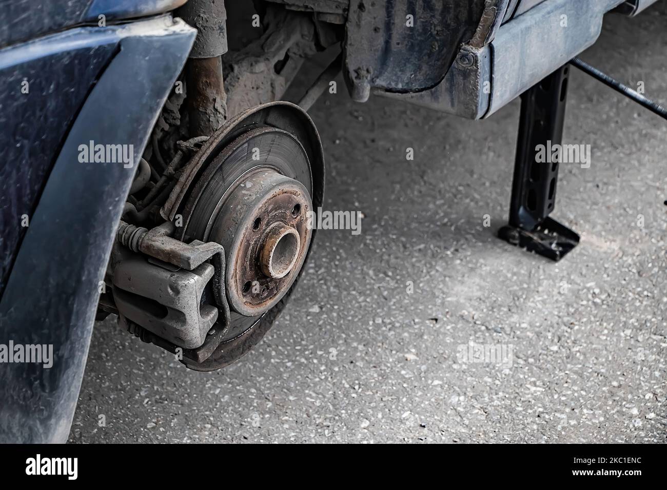 Der Automechaniker wechselt das Rad des alten Autos. Der Mann wechselt nach dem Ausfall den Reifenschaden. Nothilfe am Straßenrand. Nahaufnahme des Autorads. Stockfoto