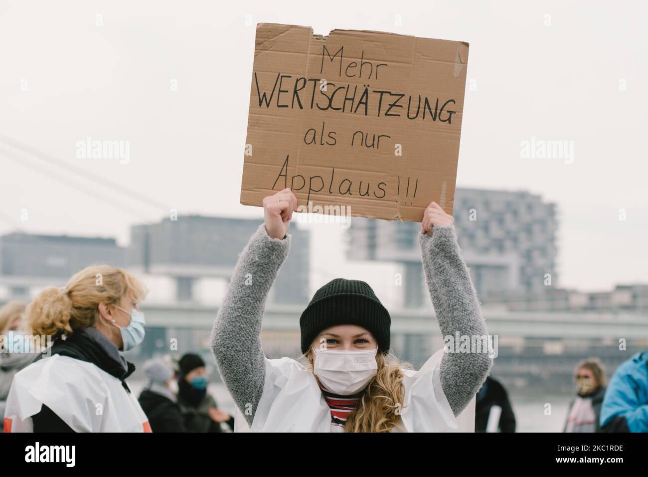 Eine Frau trägt das Plakat „Mehr sozialer Wert ist besser als Applaus“, das während der Kundgebung der verdi Union am 14. Oktober 2020 in Köln zu sehen ist. (Foto von Ying Tang/NurPhoto) Stockfoto