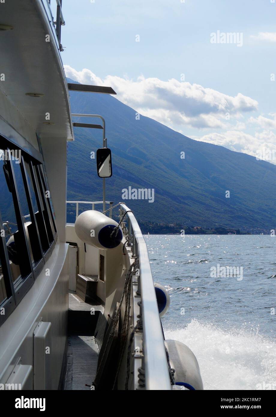 Eine schöne Aussicht vom Deck eines weißen Schiffes von Malcesine am Gardasee mit den italienischen Alpen im Hintergrund, Lombardei, Norditalien Stockfoto