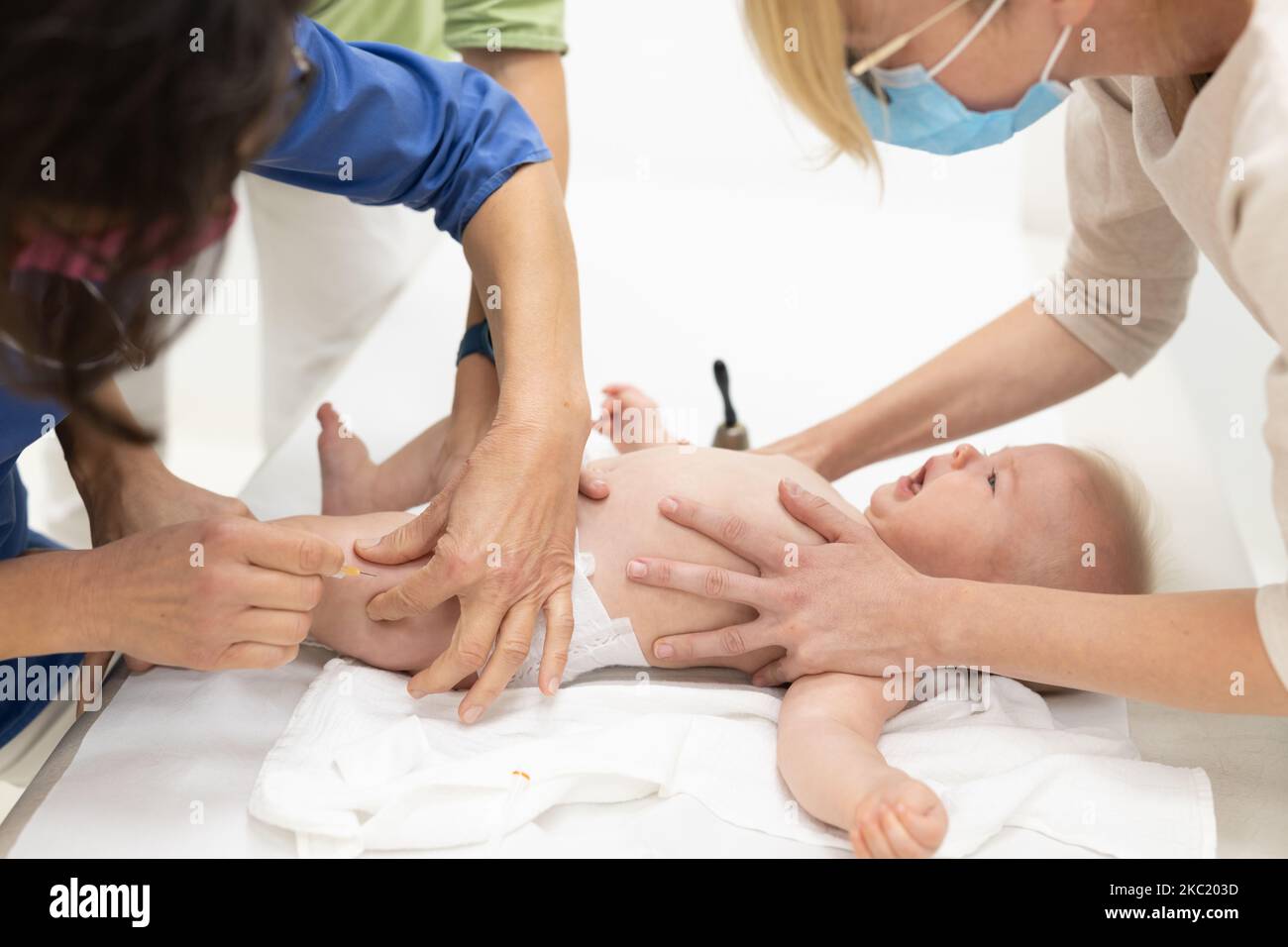 Baby wird vom Kinderarzt in Anwesenheit seiner Mutter geimpft. Vorbeugende Impfung gegen Diphtherie, Keuchhusten, Tetanus, Hepatitis, Hämophilus influenzae, Pneumokokken, Poliomyelitis. Stockfoto