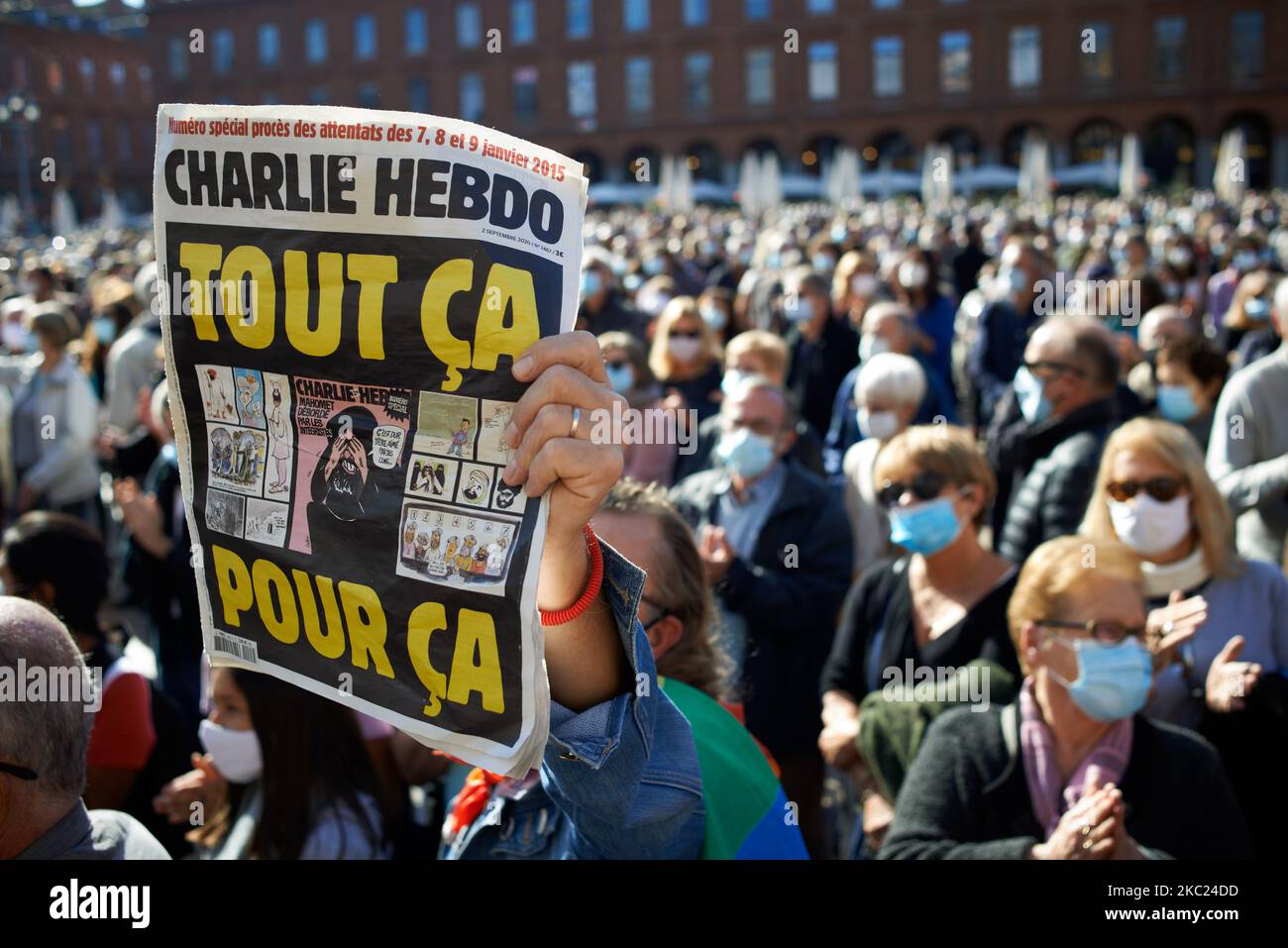 Ein Mann schwingt eine Charlie Hebdo Zeitung mit der Aufschrift „All that for this“. Nach der Tötung von Samuel Paty, Lehrer für Geographie-Geschichte, in Conflans-Sainte-Honorine (Yvelines) am 16.. Oktober versammelten sich mehrere Tausende von Menschen auf dem Hauptplatz von Toulouse, vor dem Rathaus, dem Capitole, um die Meinungsfreiheit zu verteidigen und Samuel zu ehren. Einige Leute kamen mit einem Cover von Charlie Hebdo, da der Lehrer getötet wurde, nachdem er seinen Schülern die Karikaturen von Charlie Hebdo von Muhammed gezeigt hatte. Der Mörder wurde anschließend von der französischen Polizei getötet. Am 18.. Oktober 2020 in Toulous Stockfoto