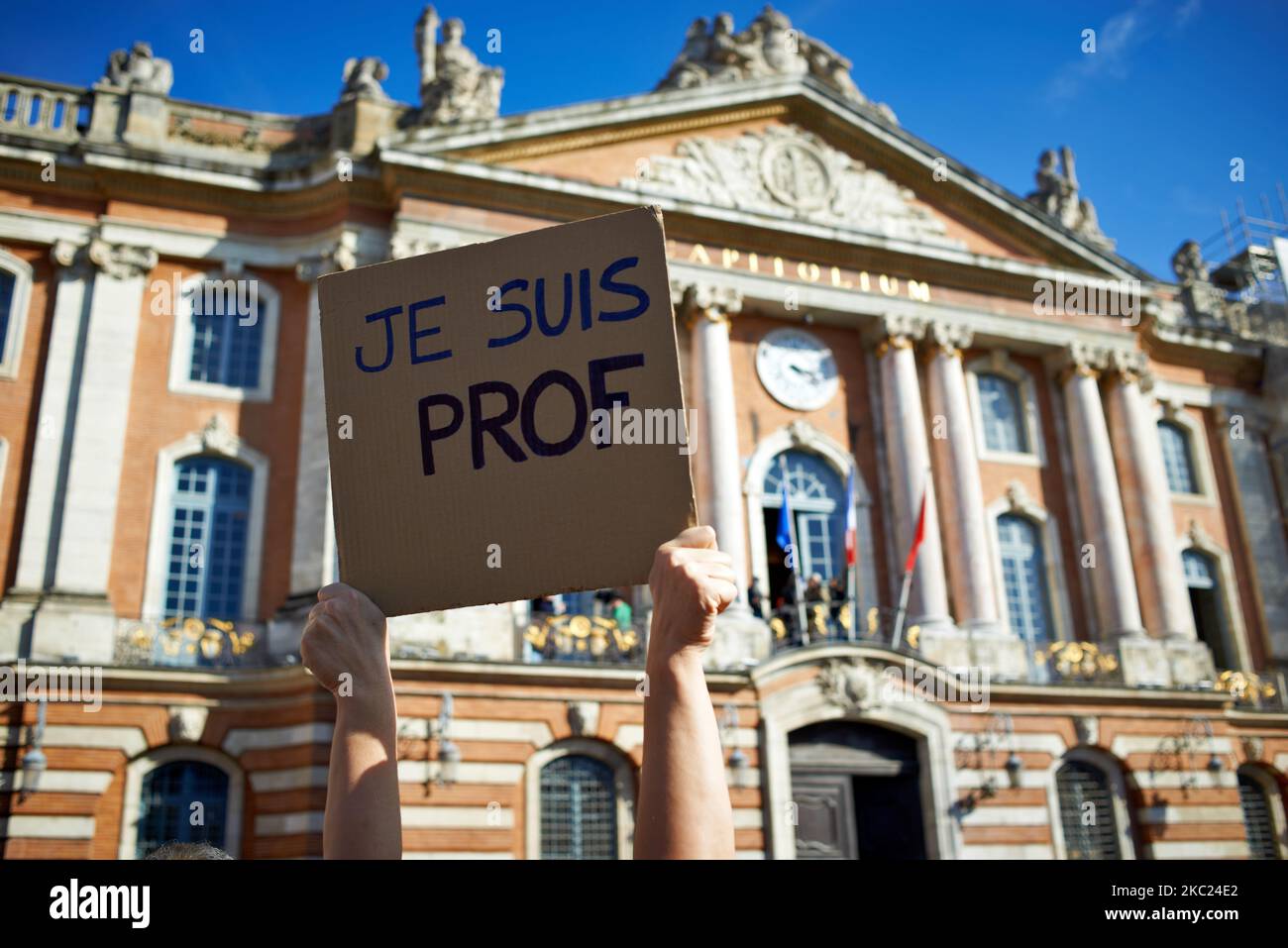 Ein Lehrer zeigt ein Plakat mit der Aufschrift „Ich bin Lehrer“ vor dem Rathaus von Toulouse, dem Capitole. Nach der Tötung von Samuel Paty, Lehrer für Geographie-Geschichte, in Conflans-Sainte-Honorine (Yvelines) am 16.. Oktober versammelten sich mehrere Tausende von Menschen auf dem Hauptplatz von Toulouse, vor dem Rathaus, dem Capitole, um die Meinungsfreiheit zu verteidigen und Samuel zu ehren. Einige Leute kamen mit einem Cover von Charlie Hebdo, da der Lehrer getötet wurde, nachdem er seinen Schülern die Karikaturen von Charlie Hebdo von Muhammed gezeigt hatte. Der Mörder wurde anschließend von der französischen Polizei getötet. Ein Stockfoto