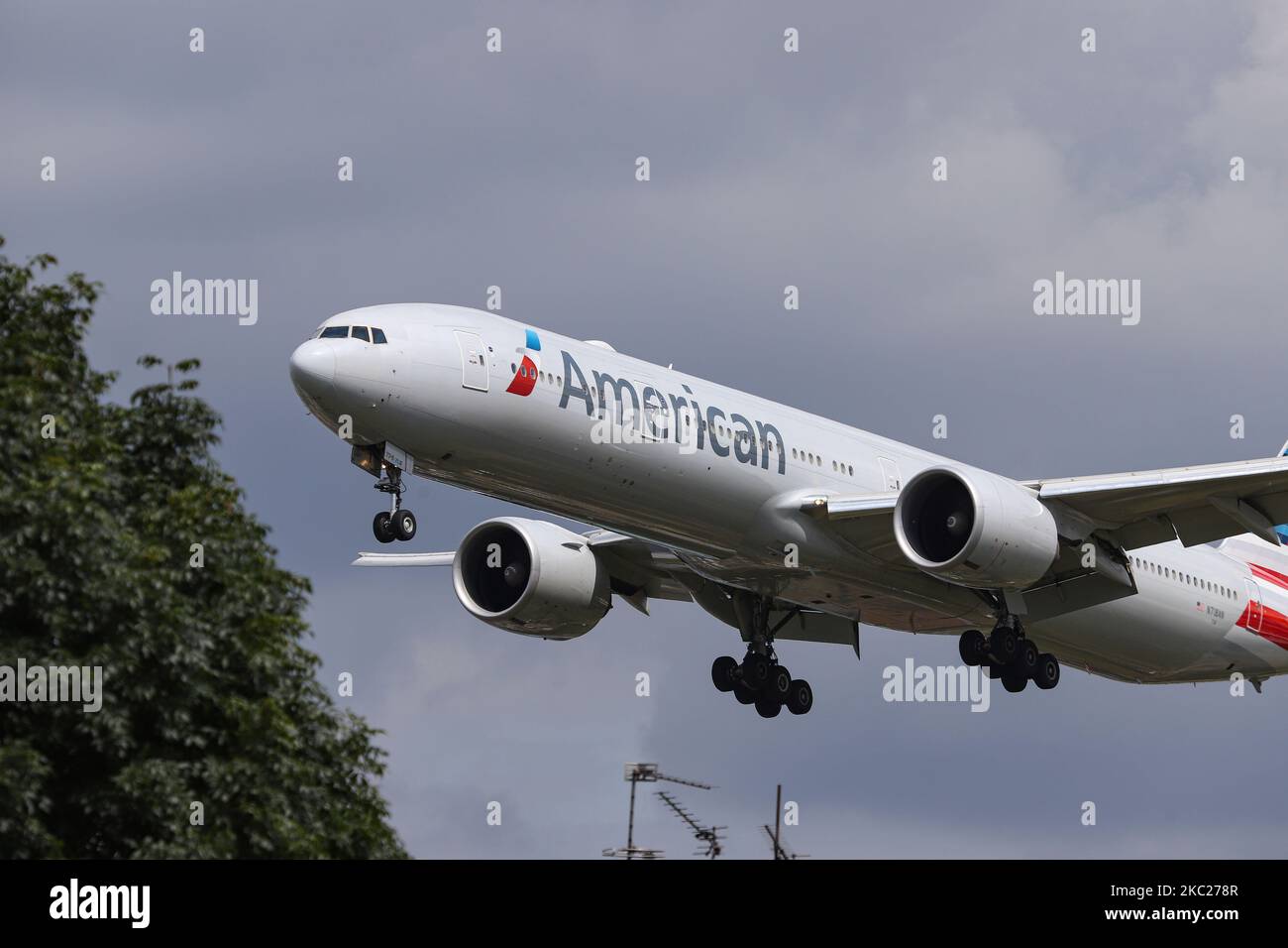 American Airlines Boing 777-300 Großraumflugzeuge, wie bei der endgültigen Annäherung über die Häuser der Myrtle Ave, für die Landung auf dem London Heathrow LHR EGLL International Airport in England, Großbritannien, gesehen. Das Flugzeug B777 hat die Registrierung N718AN und wird von 2x GE-Düsenmotoren angetrieben. American Airlines AA AAL ist die weltweit größte Fluggesellschaft mit Sitz und Drehkreuz in Fort Worth, Texas. Die 777-323(er)-Maschine wird seit dem 23. März 2020 in Tulsa TUL gelagert, weil die Coronavirus Covid-19-Pandemie den Niedergang der Luftfahrtindustrie anführte. 19. März 2020 London Heathrow (Foto von Nicolas Econo Stockfoto