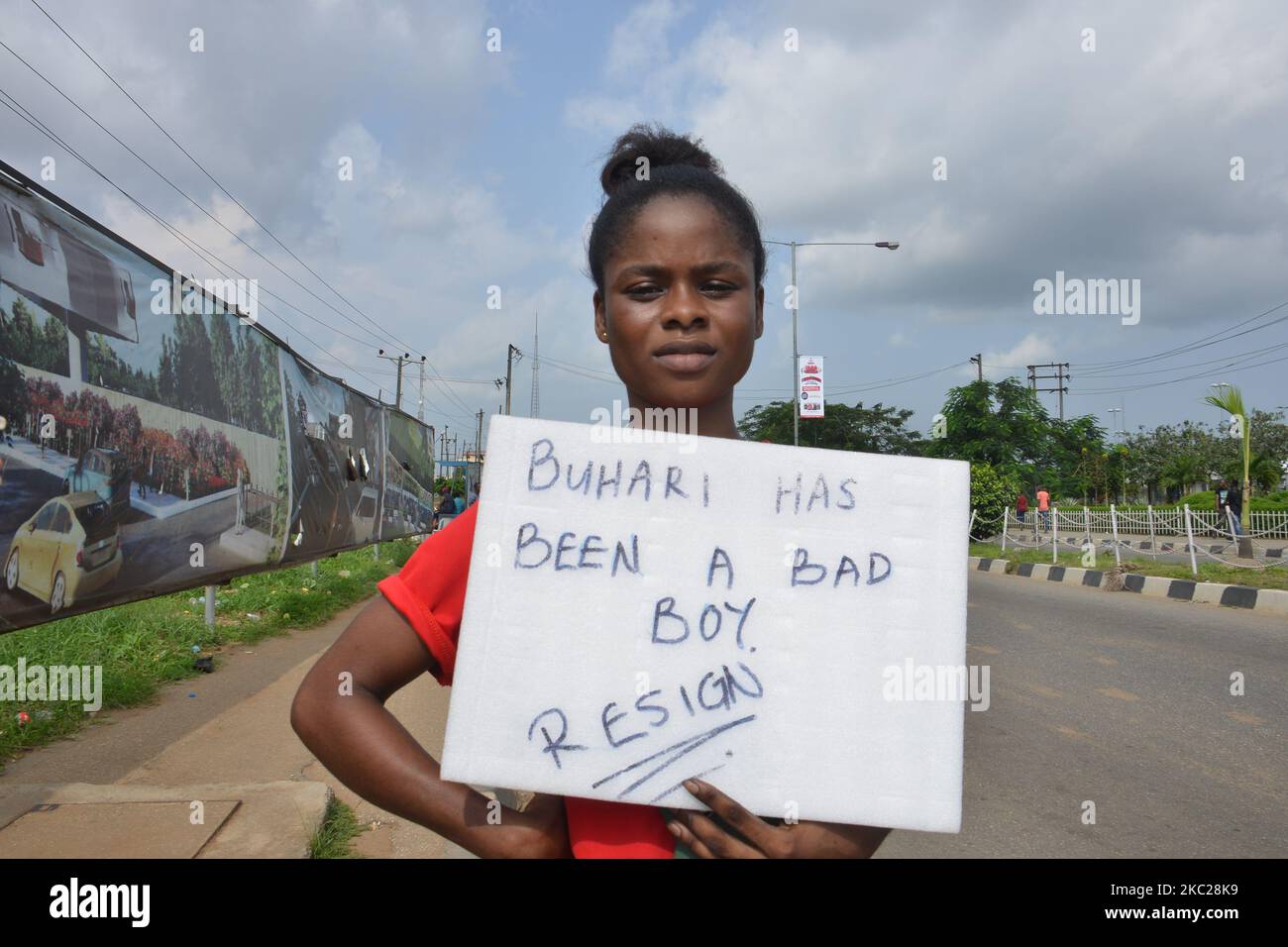 Eine Protesterin zeigt ihr Plakat, als Demonstranten während einer friedlichen Demonstration gegen die Polizeibrutalität in Nigeria am 20. Oktober 2020 die Hauptautobahn zwischen Lagos und anderen Teilen des Landes im Bundesstaat Alausa verbarrikadierten. Die Gouverneurin des Staates Lagos, Babajide Sonwo-Olu, hat am Dienstag aufgrund der gewalttätigen Angriffe auf Polizisten und unschuldige Nigerianer eine 24-Stunden-Ausgangssperre gegen den Staat verhängt, die am 4pm. (Foto von Olukayode Jaiyeola/NurPhoto) Stockfoto