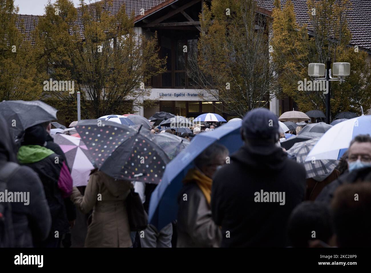 In der Mittelschule in Conflans-Sainte-Honorine, nordwestlich von Paris, versammeln sich am 20. Oktober 2020 Menschen während der "Marche Blanche" in Solidarität, nachdem ein Lehrer enthauptet wurde, weil er den Schülern Karikaturen des Propheten Mohammed gezeigt hatte. Sein Mord in einem Pariser Vorort am 16. Oktober schockierte das Land und brachte Erinnerungen an eine Welle islamistischer Gewalt im Jahr 2015 zurück. Paty, 47, wurde am 16. Oktober auf dem Weg von der Mittelschule nach Hause angegriffen, wo er vom 18-jährigen Tschetschenien Abdullakh Ansorov unterrichtete, der von der Polizei getötet wurde. Nach dem Angriff nahmen Zehntausende von Menschen an Kundgebungen Teil Stockfoto