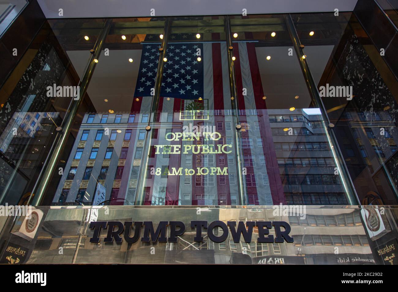 Der Haupteingang des Trump Tower mit der Aufschrift und einer US-Flagge. Trump Tower in New York City in den USA. Der 58-stöckige Wolkenkratzer an der Fifth Avenue in Midtown Manhattan beherbergt das Hauptquartier der Trump Organization und die Penthouse-Eigentumswohnung des US-Präsidenten Donald Trump, der auch Geschäftsmann und Immobilienentwickler ist. Das Gebäude wurde von der Scutt in modernistischen Architektur mit Glas und Treppenfassade am Gebäude entworfen, der Bau begann im Jahr 1979 in NYC. New York, USA am 2020. Februar (Foto von Nicolas Economou/NurPhoto) Stockfoto