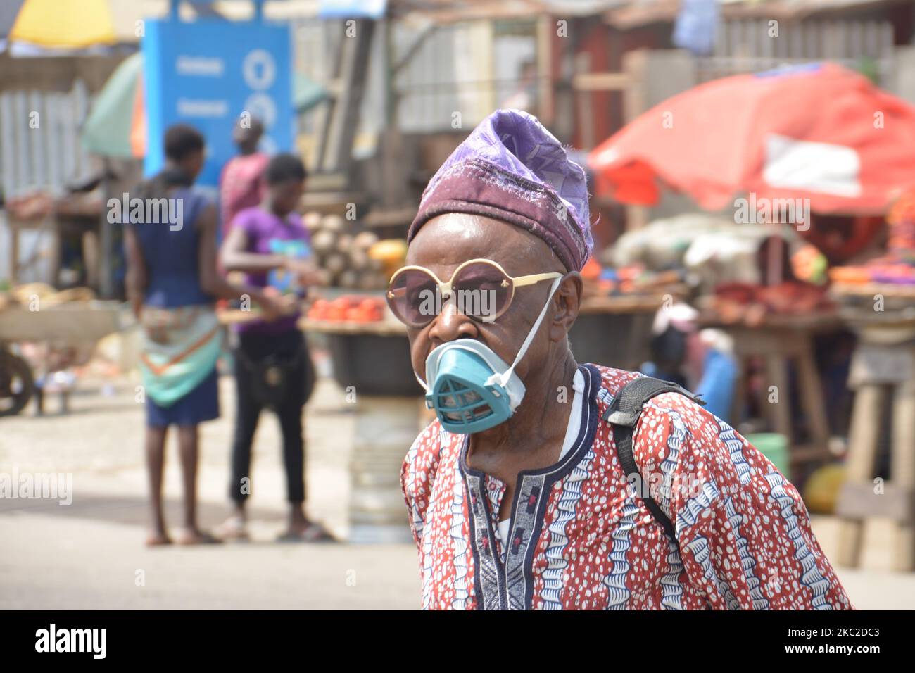 Männer mit Nasenmaske laufen am 23. Oktober 2020 in Lagos am Ojodu Berger an einem Vandalismus-Auto vorbei. Der Gouverneur von Lagos, Babajide Sonwo-Olu, entspannt die landesweite Ausgangssperre von Samstag auf 8am bis 6pm Uhr am Abend. (Foto von Olukayode Jaiyeola/NurPhoto) Stockfoto