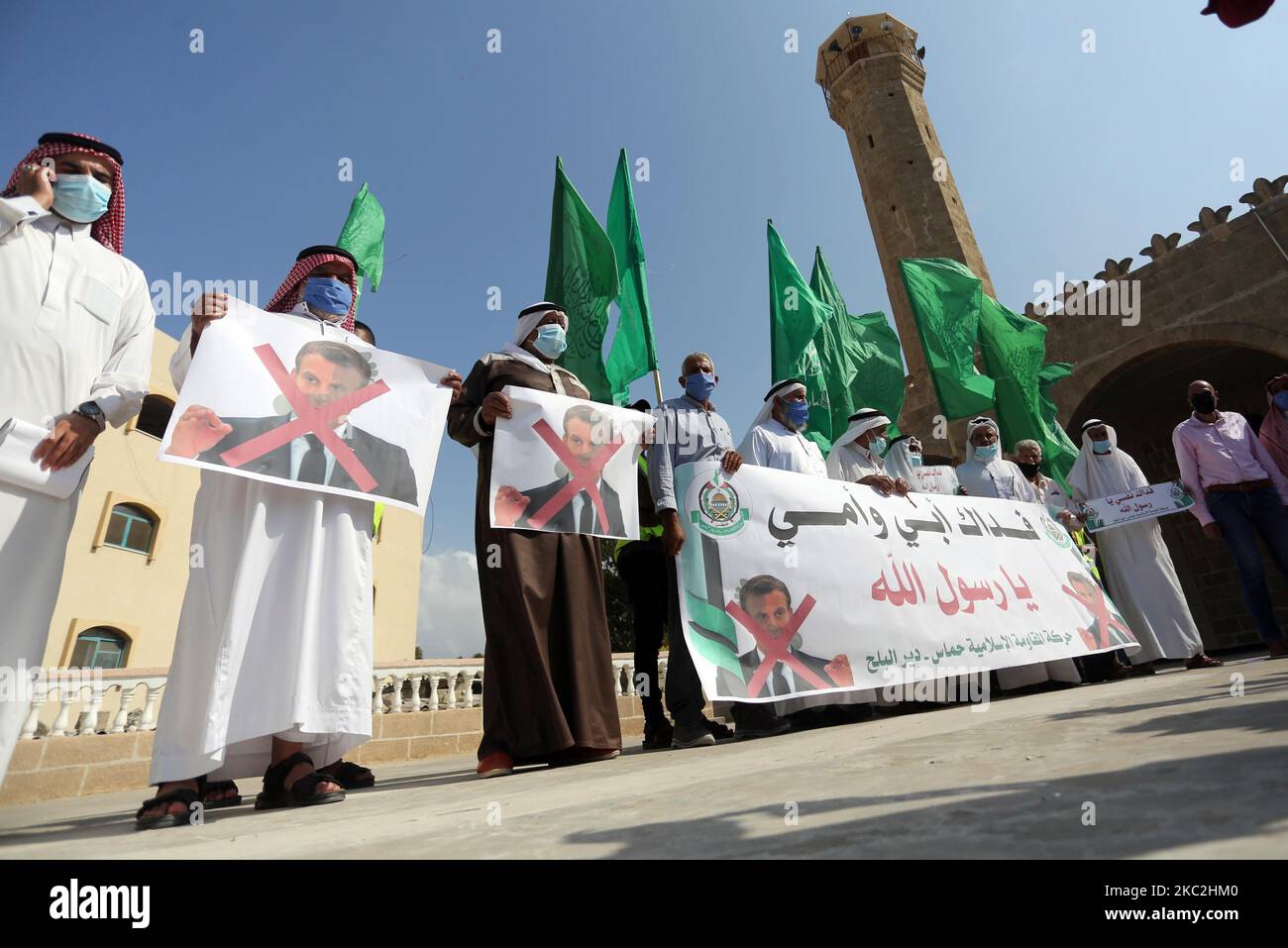 Während einer Kundgebung heben stinische Demonstranten am 25. Oktober 2020 in Deir al-Balah im zentralen Gazastreifen Plakate auf, um gegen die Kommentare des französischen Präsidenten Emmanuel Macron über die Karikaturen des Propheten Mohammed zu protestieren. (Foto von Majdi Fathi/NurPhoto) Stockfoto