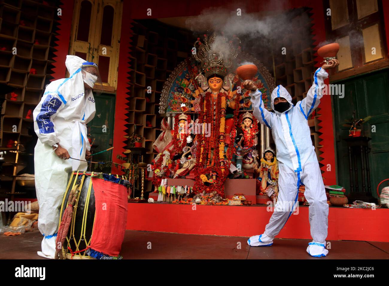 Hindu-Anhänger, die persönliche Schutzausrüstung tragen, führen Dhunuchi, einen traditionellen Tanz, am 25. Oktober 2020 vor einem Idol der Hindu-Göttin Durga während des Durga Puja Festivals in der Gemeinschaft Puja Pandal inmitten der COVID-19 Pandemie in Kalkutta, Indien, vor. (Foto von Debajyoti Chakraborty/NurPhoto) Stockfoto