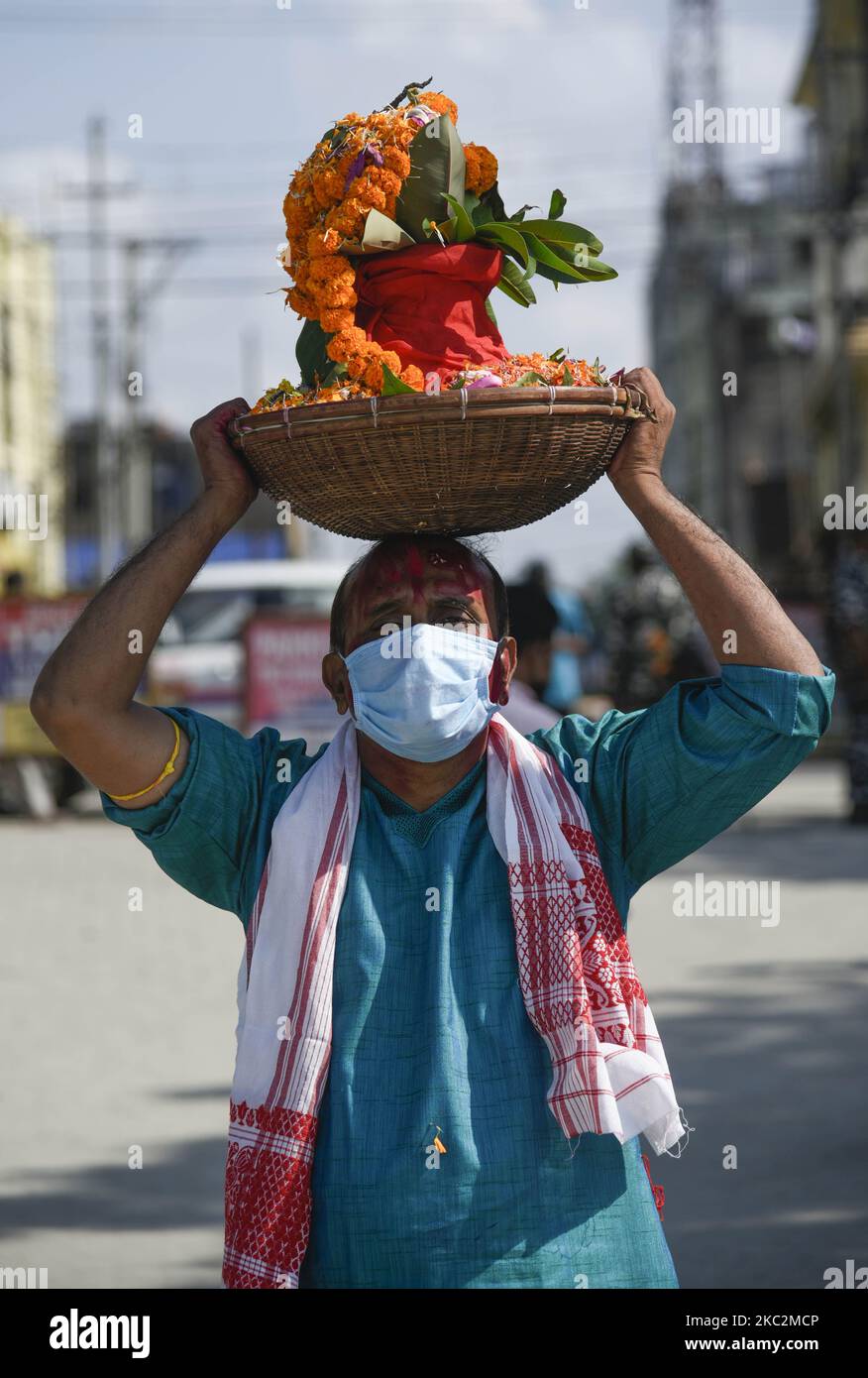 Ein Anhänger kommt am 26. Oktober 2020 in Kasamari Ghat an, um sich während des Durga Puja Festivals in Guwahati, Indien, in die Gewässer des Brahmaputra Flusses einzutauchen. Der letzte Tag des Festivals heißt Vijay Dashmi, Vijaya bedeutet „Sieg“ und Dashmi bedeutet „Zehnter“. Durga Puja wird in den indischen Bundesstaaten Westbengalen, Assam, Jharkhand, Orissa und Tripura weithin gefeiert und gipfelt im Eintauchen der Idole der Hindu-Göttin Durga, die in der hinduistischen Mythologie Macht und den Triumph des Guten über das Böse symbolisiert. (Foto von David Talukdar/NurPhoto) Stockfoto