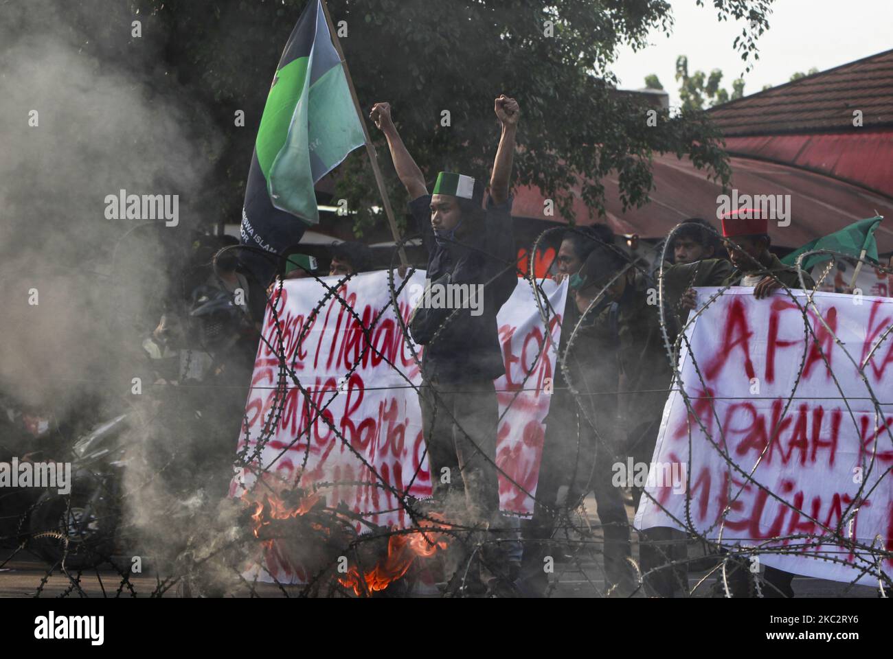 Indonesische Studenten rufen Slogans aus und verbrennen Reifen während des Protestes gegen ein neues Arbeitsgesetz, von dem sie befürchten, dass es den Investoren auf Kosten der Arbeitnehmerrechte und der Umwelt zugute kommen wird, in Bogor, 28. Oktober 2020. (Foto von Adriana Adie/NurPhoto) Stockfoto