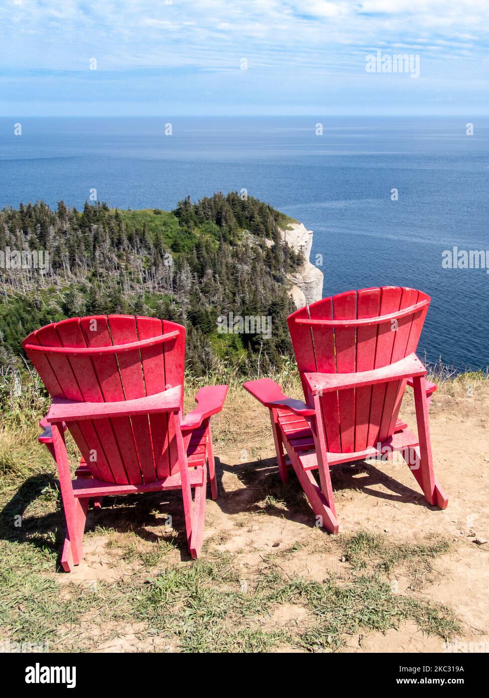 Blick auf Land's End (Bout du monde) in Forillons Park, Gaspe, Quebec, Kanada. Zwei rote Adirondack-Stühle für Menschen, um die Landschaft zu bewundern. Stockfoto