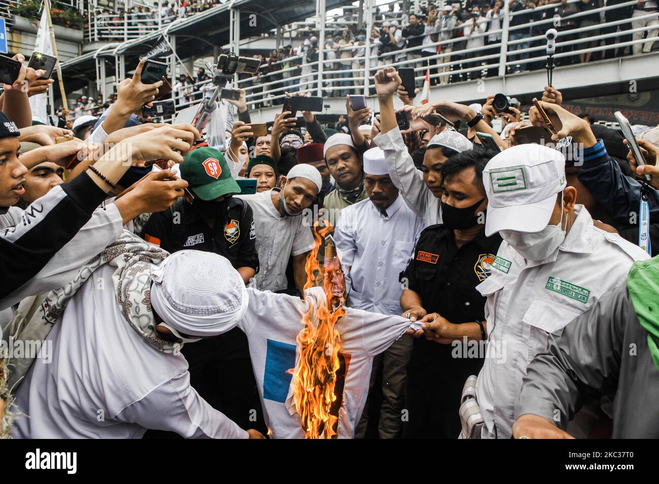 Der Protestierende verbrennt ein Foto des französischen Präsidenten Emmanuel Macron während eines Protestes in der Nähe des französischen Botschafters in Jakarta, Indonesien, am 02. November 2020. Die Proteste und Aufrufe zum Boykott französischer Produkte, nachdem Macron einen französischen Lehrer kommentiert hatte, der enthauptet wurde, weil er Karikaturen des Propheten Muhammad in der Klasse zeigte. (Foto von Agoes Rudianto/NurPhoto) Stockfoto