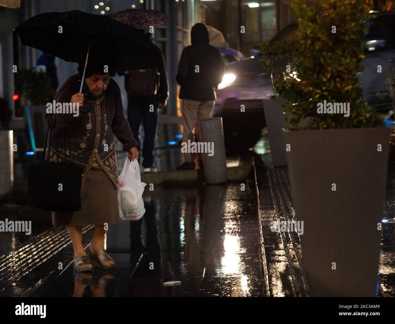 Alte Frau mit Regenschirm, die im Regen läuft, in Nikosia, Zypern, 4. November 2020. (Foto von George Christophorou/NurPhoto) Stockfoto