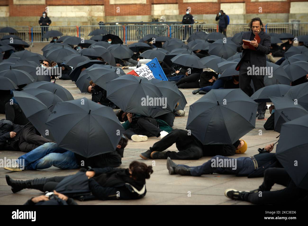 Eine Opernsängerin singt Nabucco während des Protestes. Demonstranten, Unternehmer aus verschiedenen Wirtschaftssektoren (Cafés, Restaurants, Theater, Buchhandlungen...) versammelten sich, um ein Ereignis gegen die Schließung von "nicht-wesentlichen" Unternehmen auf dem Hauptplatz von Toulouse, dem Capitole, zu Unternehmen. Sie taten ihr Geschehen während einer 2. verhängten Sperre, um zu versuchen, die Ausbreitung des SARS-Cov-2-Coronavirus einzudämmen, das die Covid-19-Unheinheit verursacht. Diese Sektoren sind die von der Wirtschaftskrise am stärksten betroffenen, sie fordern konkrete Maßnahmen der Regierung. Sie verwendeten schwarze Schirme, um ihr Verschwinden zu symbolisieren. Am 6.. November Stockfoto
