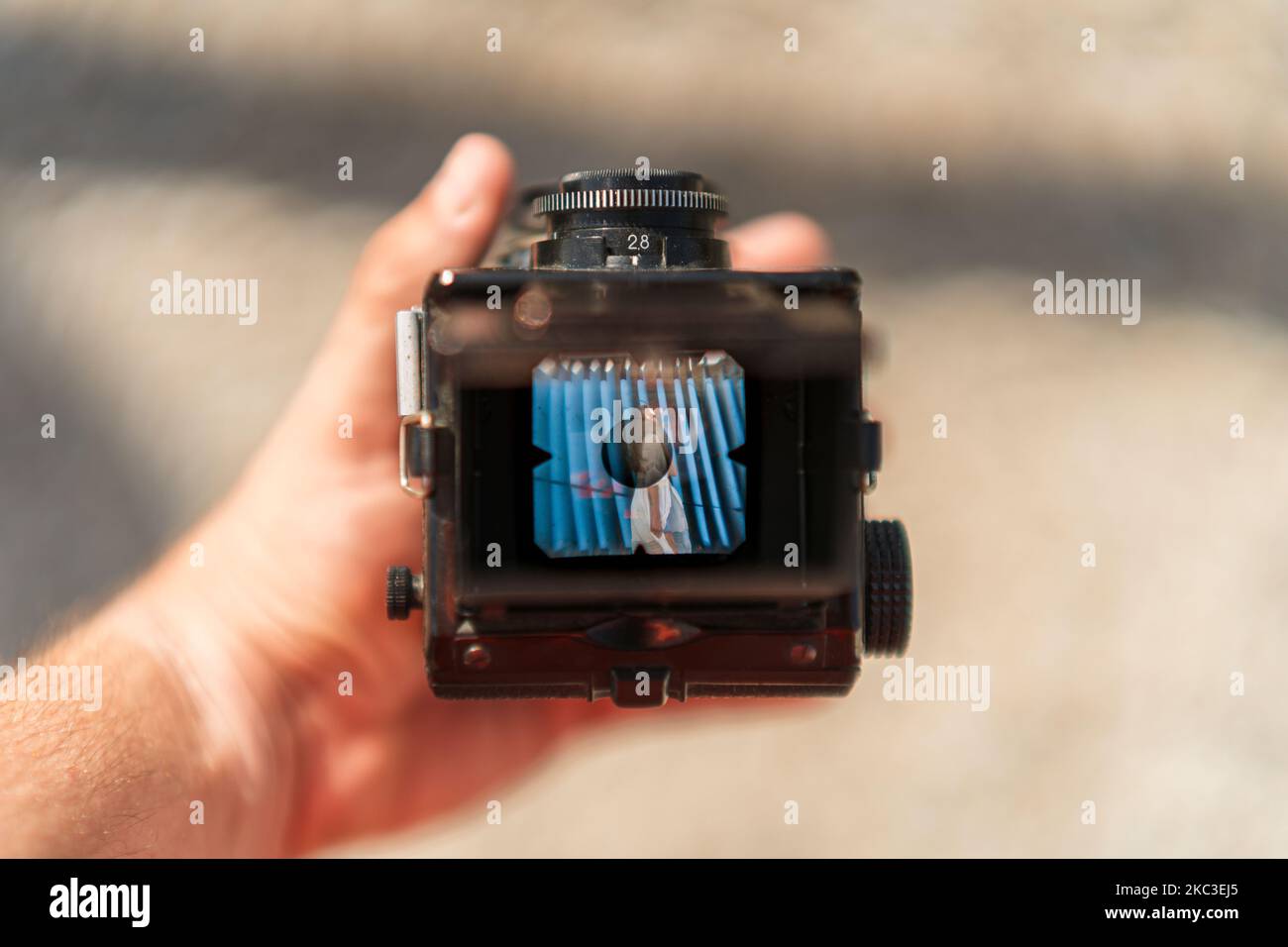 Eine Hand hält eine Spiegelreflexkamera mit einem Bild eines Mädchens auf dem Display Stockfoto