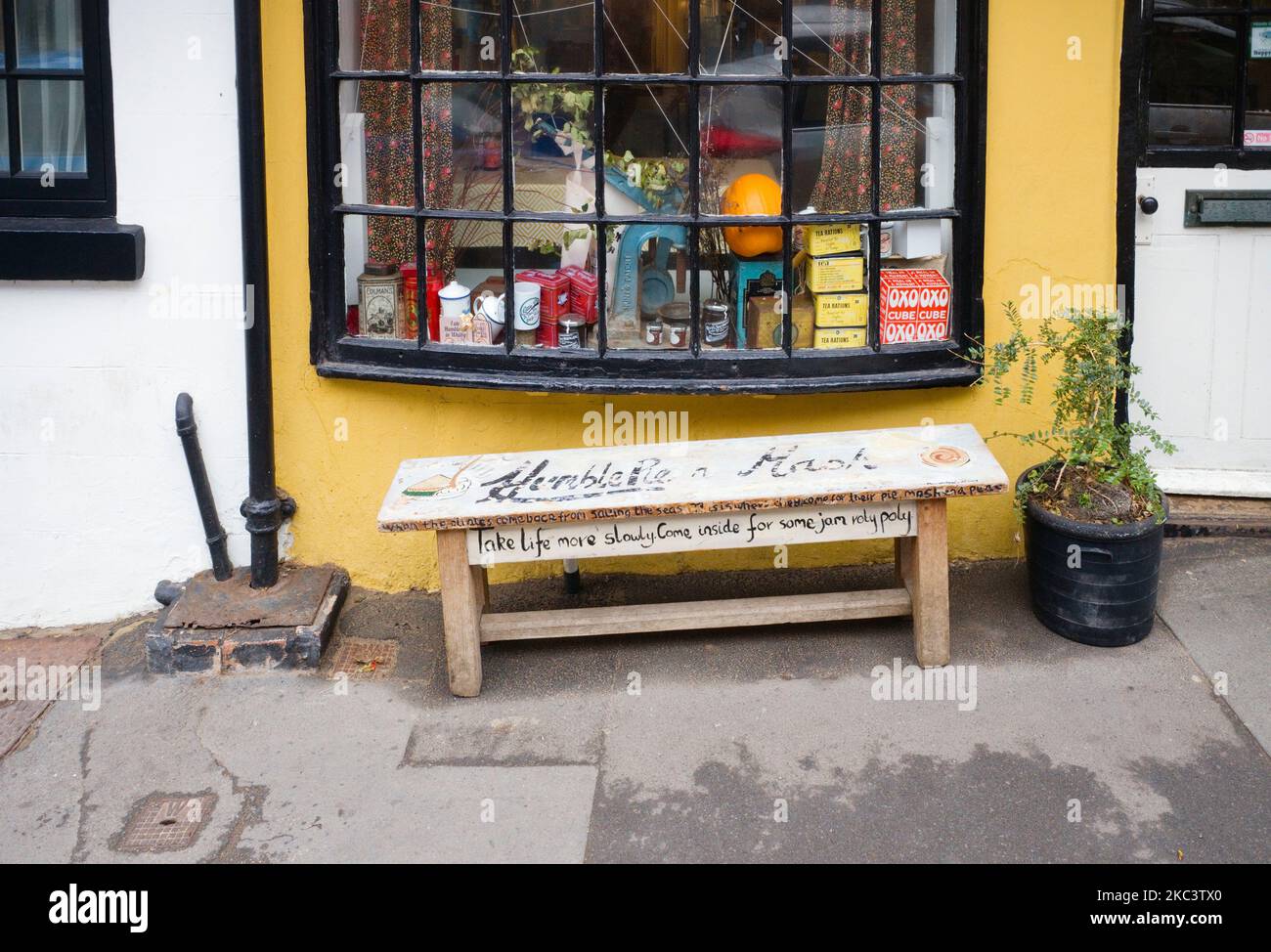 Restaurantfenster und Bank draußen in Whitby, North Yorkshire. Kommt herein, um ein paar Stau-Roly-Poly zu machen. Stockfoto