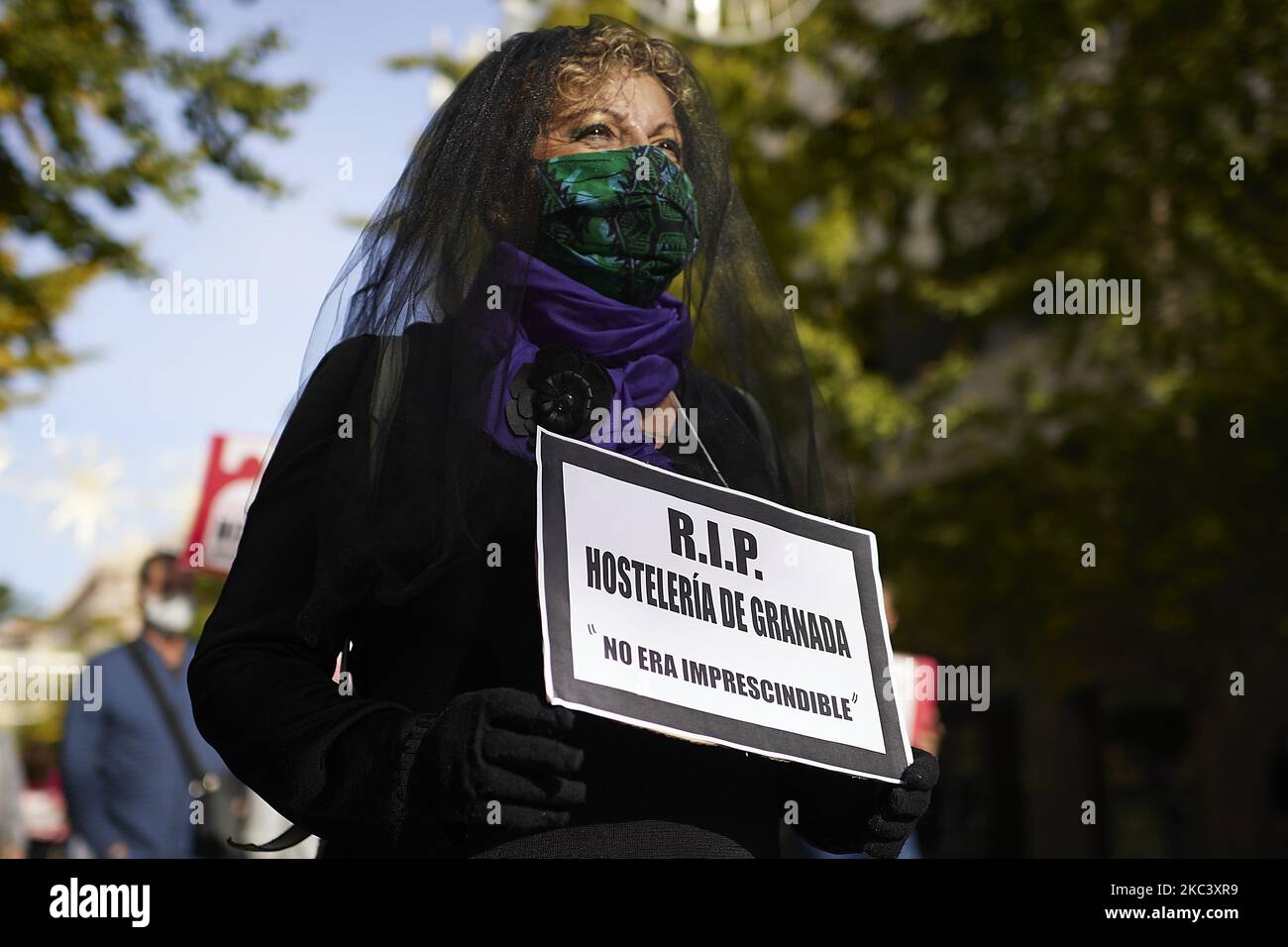 Eine trauernde Frau mit einem Nachruf-Schild mit der Aufschrift „RIP Granada Hostelry: IT was not Essential“ während einer Demonstration von Gastgeberinnen und Gastarbeitern, die am 12. November 2020 in Granada, Spanien, um Hilfe in ihren Betrieben gegen die neuesten Virenbeschränkungen baten. Seit November 10 sind Bars und Restaurants in Granada geschlossen, alle nicht notwendigen Gaststätten sind verpflichtet zu schließen, außer dass sie nur Speisen und Getränke zum Mitnehmen und zur Lieferung servieren. Mitarbeiter von Gaststätten wie Kellner, Köche und Restaurantbesitzer demonstrieren nach den von der an verhängten Maßnahmen, um Hilfe in ihren Betrieben zu bitten Stockfoto