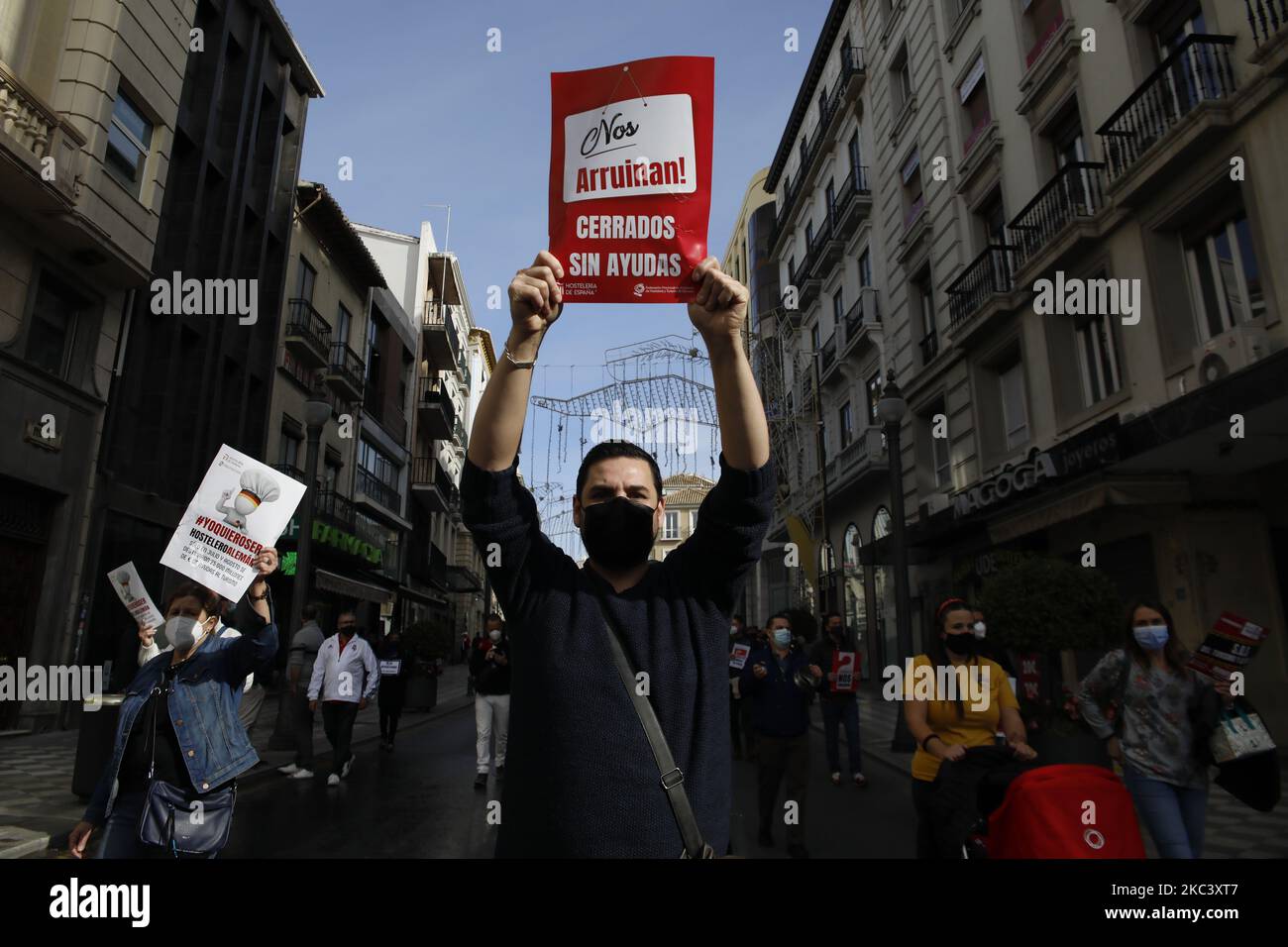 Ein Mann trägt ein Schild mit dem Text, der ohne Hilfe geschlossen wurde, während der Demonstration von Bars, Restaurants und lokalen Handelsarbeitern am 12. November 2020 in Granada, Spanien. Bars, Restaurants und Hotelangestellte protestieren, weil die andalusische Regierung neue Maßnahmen zur Beendigung der zweiten Welle von Coronavirus-Infektionen in Granada (Spanien) ergriffen hat, wie die Schließung aller nicht wesentlichen kommerziellen Aktivitäten für zwei Wochen und 24 Stunden am Tag. (Foto von Ãlex CÃ¡mara/NurPhoto) Stockfoto