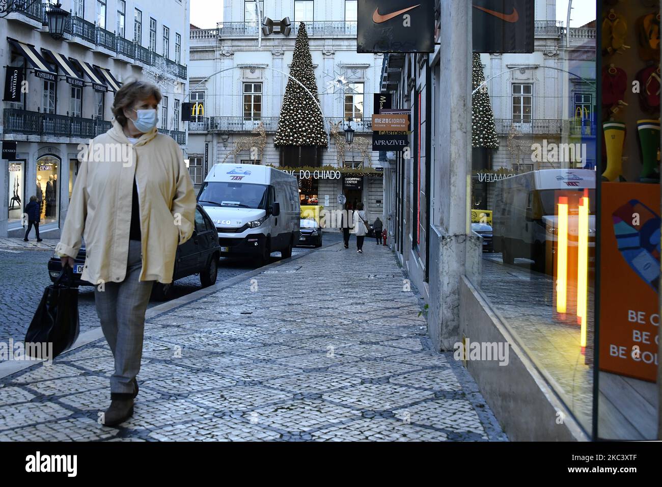 Eine Frau, die Schutzmasken trägt, geht im Bezirk Chiado in Lissabon spazieren. 12.. November 2020. Am 4. November trat in Portugal eine Teilhaft in 121 Gemeinden auf dem portugiesischen Festland in Kraft, in denen ein „hohes Risiko der Übertragung von Covid-19“ besteht, wobei die Pflicht zum Aufenthalt zu Hause angewandt wird, mit Ausnahme von genehmigten Reisen wie Einkaufen, Arbeit, Unterricht und körperlicher Betätigung. Zusätzlich zu den spezifischen Maßnahmen für diese Gemeinden verlängert die Resolution des Ministerrats die Erklärung des Unglücks im gesamten Staatsgebiet des Kontinents bis Novembe Stockfoto