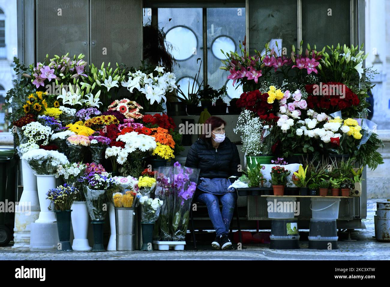 Ein Blumenverkäufer, der eine Schutzmaske trägt, bleibt im Rossio Park im Stadtteil Baixa in Lissabon. 12. November 2020. Am 4. November trat in Portugal eine Teilhaft in 121 Gemeinden auf dem portugiesischen Festland in Kraft, in denen ein „hohes Risiko der Übertragung von Covid-19“ besteht, wobei die Pflicht zum Aufenthalt zu Hause angewandt wird, mit Ausnahme von genehmigten Reisen wie Einkaufen, Arbeit, Unterricht und körperlicher Betätigung. Zusätzlich zu den spezifischen Maßnahmen für diese Gemeinden, die Entschließung des Ministerrats, erweitert die Erklärung des Zustands der Katastrophe im gesamten Staatsgebiet von Stockfoto