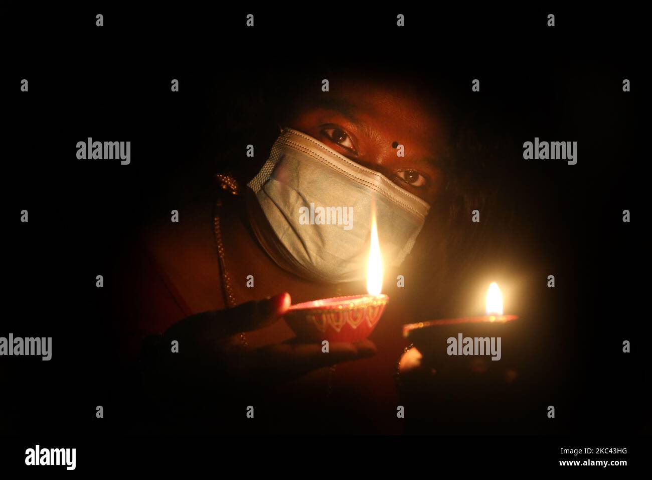 Hindu-Frau, die eine Gesichtsmaske trägt, um sie vor dem neuartigen Coronavirus (COVID-19) zu schützen, während sie Diyas (kleine Tonlampen) während des Festivals von Diwali in einem Hindu-Tempel in Toronto, Ontario, Kanada, am 14. November 2020 hält. (Foto von Creative Touch Imaging Ltd./NurPhoto) Stockfoto Hindu-Frau, die eine Gesichtsmaske trägt, um sie vor dem neuartigen Coronavirus (COVID-19) zu schützen, während sie Diyas (kleine Tonlampen) während des Festivals von Diwali in einem Hindu-Tempel in Toronto, Ontario, Kanada, am 14. November 2020 hält. (Foto von Creative Touch Imaging Ltd./NurPhoto) Stockfoto
